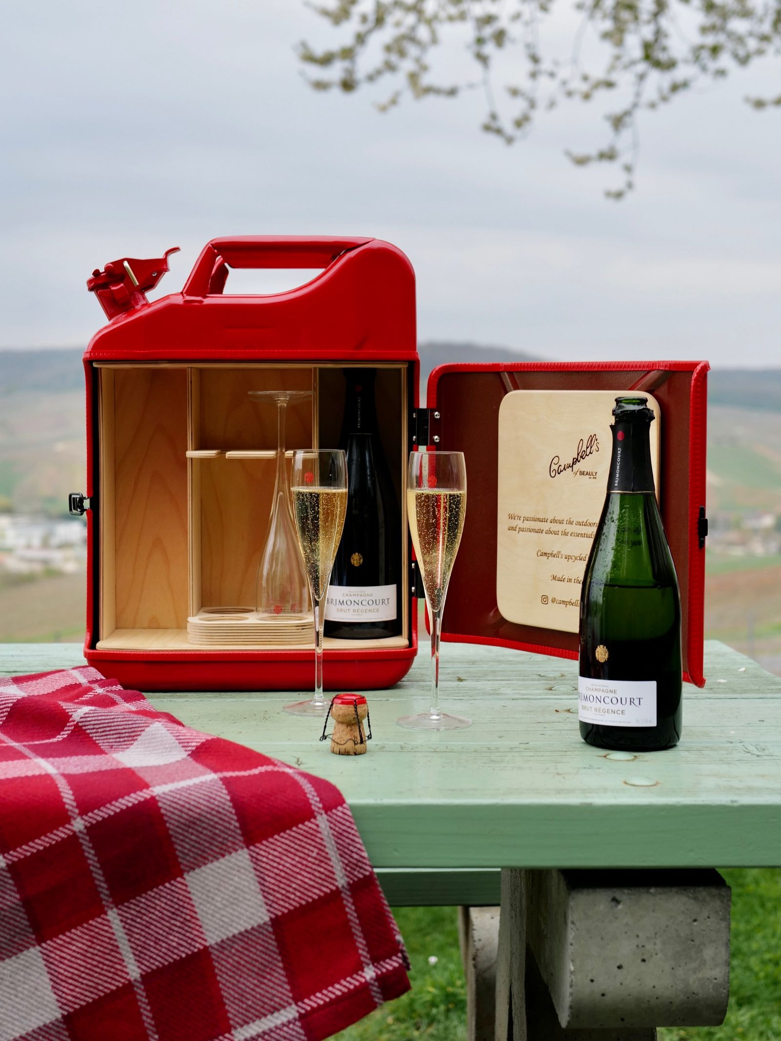 The Brimoncourt Champagne Upcycled Jerry Can for Glasses by Campbell's of Beauly serves champagne and flutes in style, with dedicated glassware compartments—perfect for an unforgettable picnic or unique home bar experience.