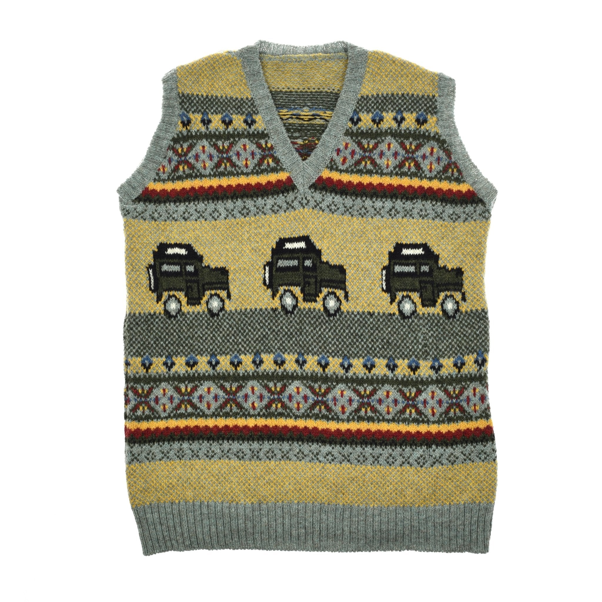 The Land Rover Defender Fairisle Slipover by Campbells of Beauly is a premium wool V-neck sweater vest with yellow, gray, red, and blue fairisle patterns and three black trucks across the front, finished with gray ribbed trim.