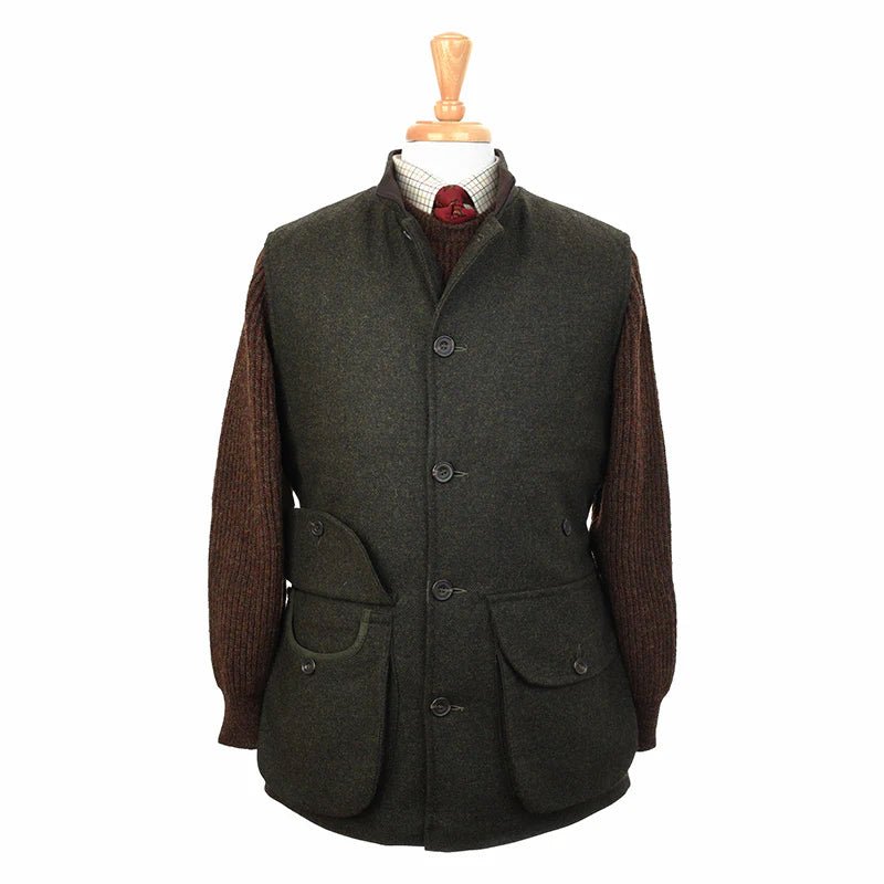 The Field Nehru Gilet by Campbell's of Beauly is a dark green British tweed vest with large front pockets, black buttons, and a quilted lining, shown over a brown sweater and red tie on a wooden mannequin.