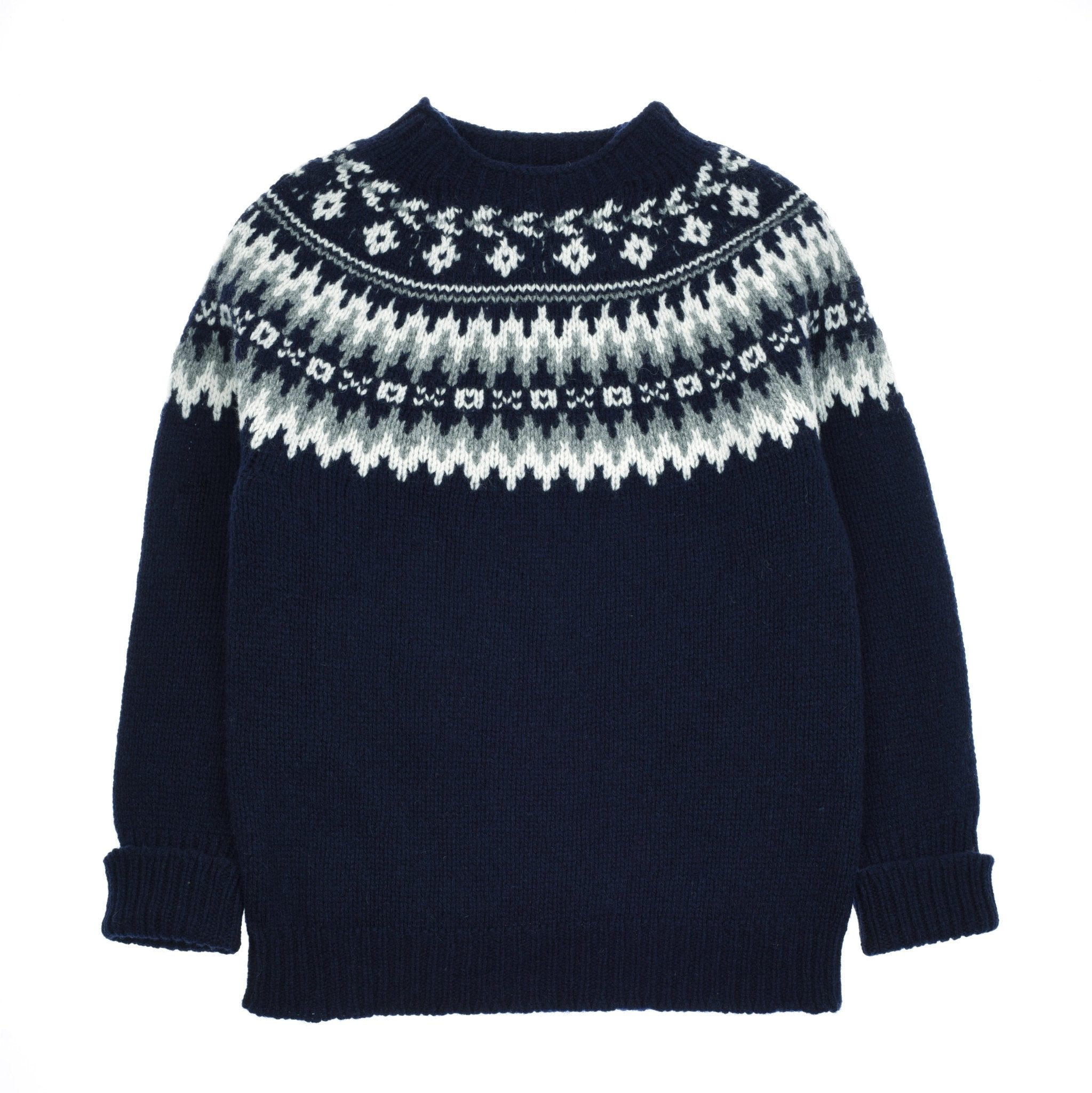 The Chunky Fairisle Jumper by Campbells of Beauly comes in navy with a white and gray geometric pattern, round neckline, and ribbed cuffs. Cozy Shetland wool makes it the perfect winter staple.