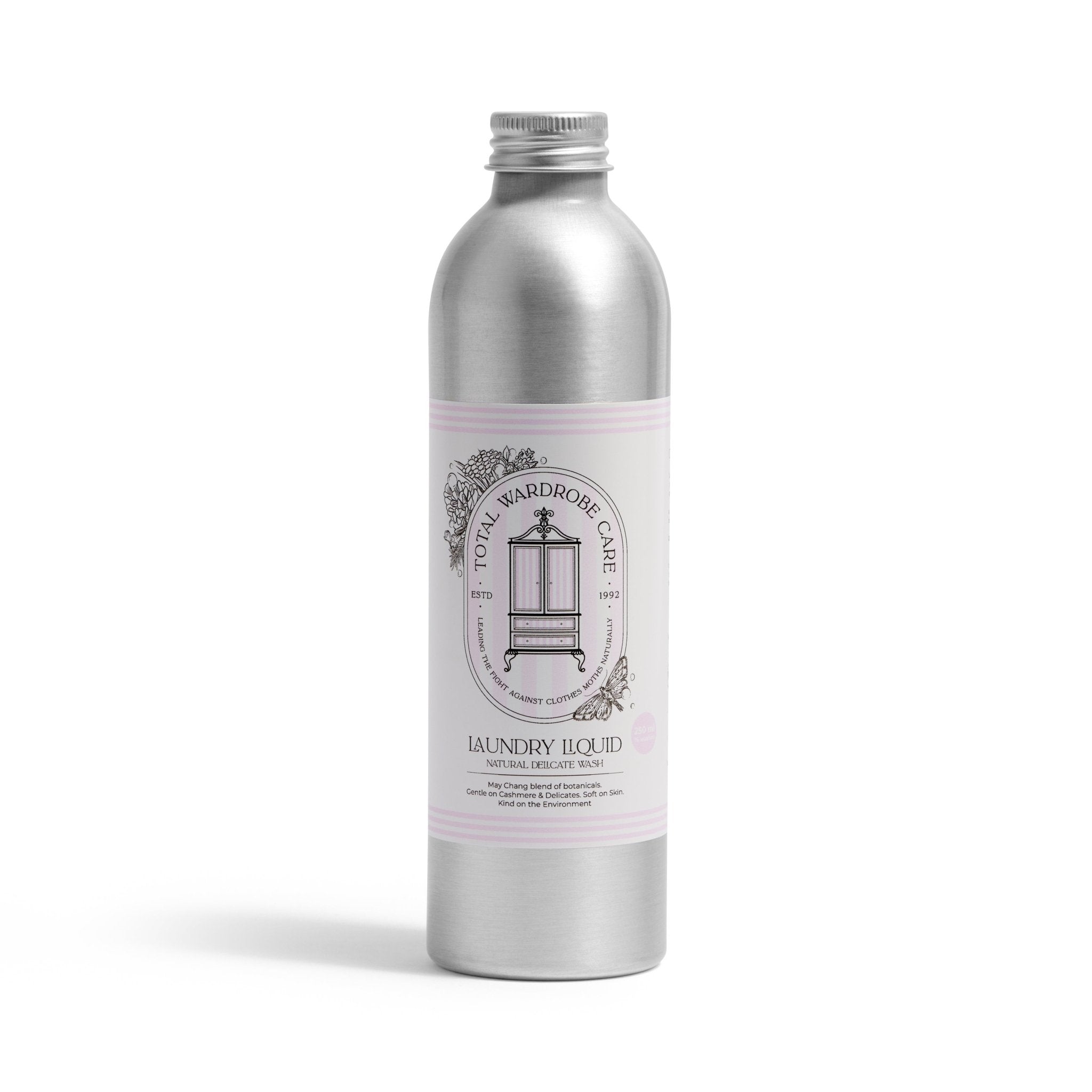 A silver metal bottle with a white and light pink label reads Total Wardrobe Care Laundry Liquid, featuring an ornate wardrobe logo. This non-biological detergent is ideal for washing delicate wool and cashmere garments.