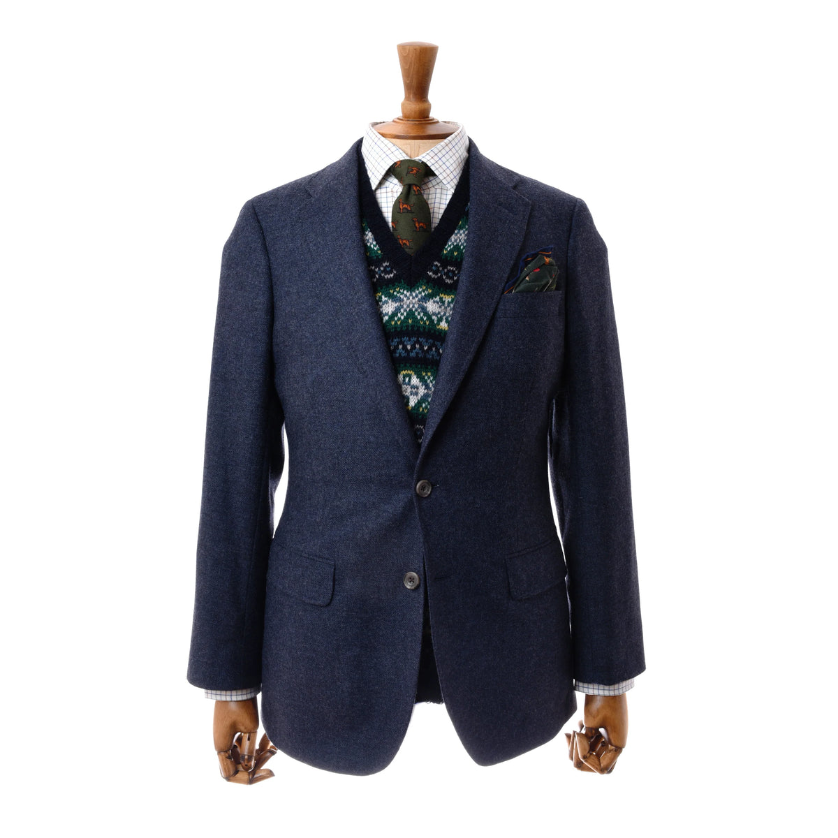 Auld Stock Navy House Jacket by Campbell’s of Beauly, shown on a wooden mannequin with a patterned sweater vest, white checkered dress shirt, patterned tie, and matching pocket square. Plain white background.