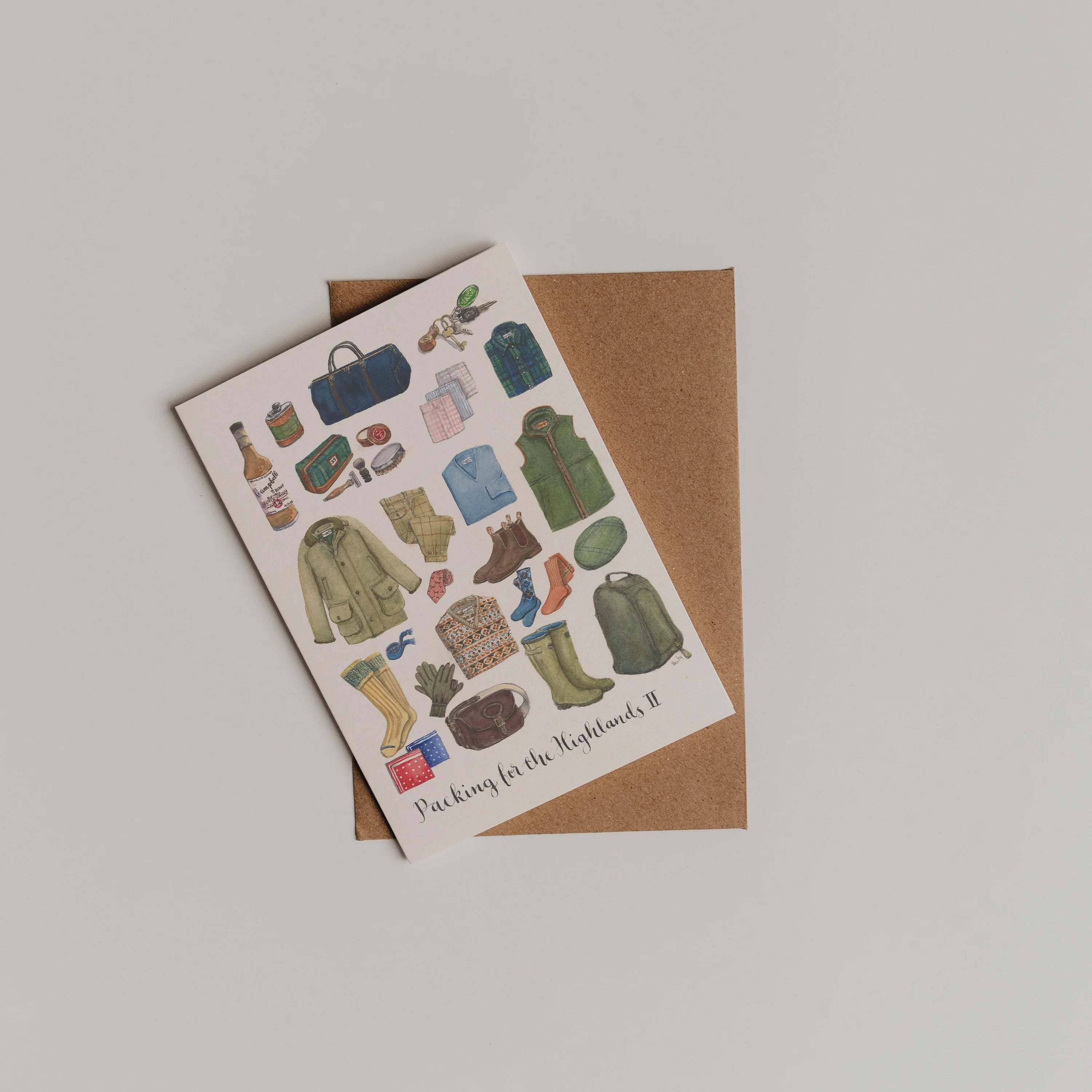 The Packing for the Highlands Greeting Card by Campbells of Beauly shows illustrated travel items. Ideal as a thank you note, the card is shown atop a brown envelope on a light background.
