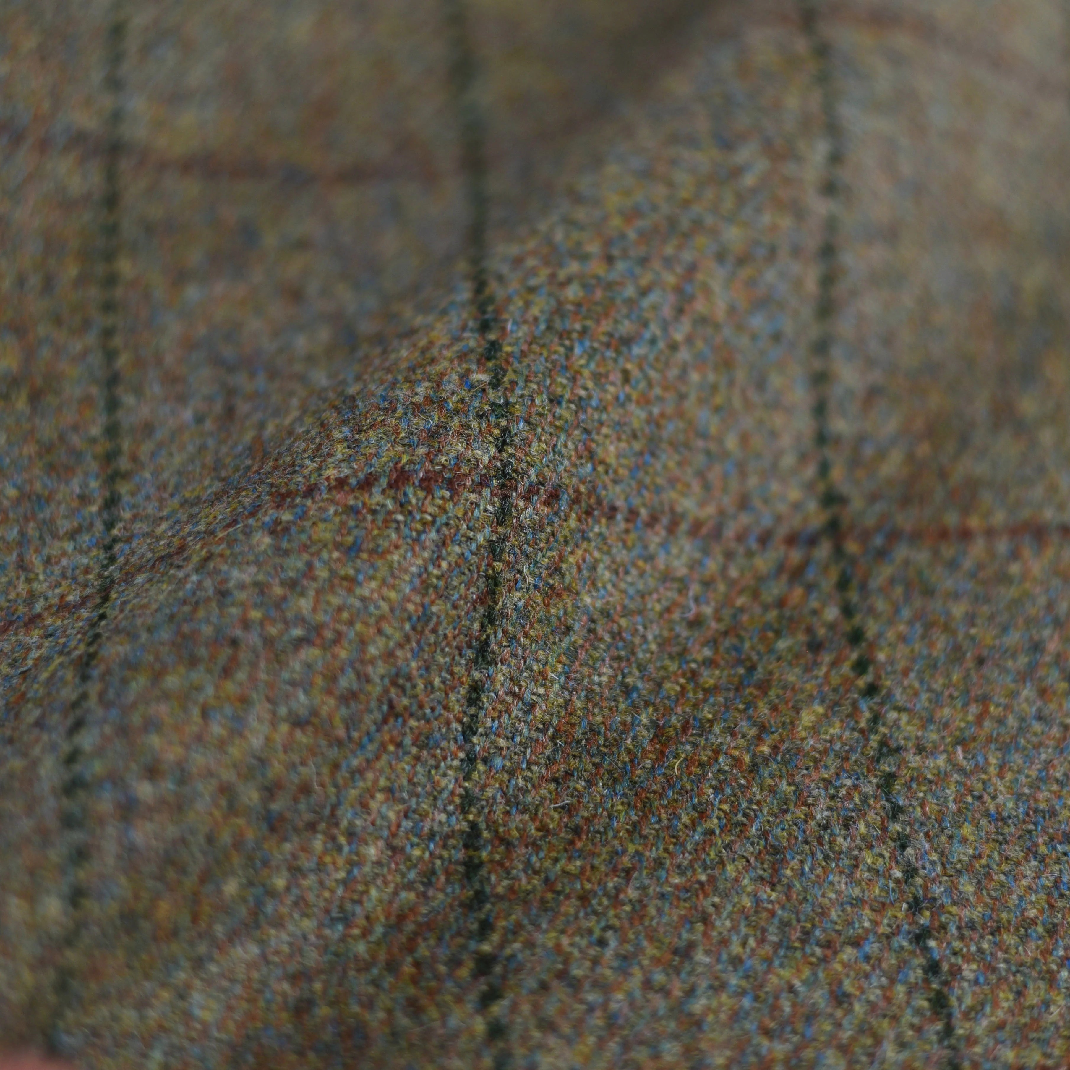 Close-up of House Tweed 30175 by Campbells of Beauly—textured Scottish estate fabric with a brown and green check, fine stitching, and a soft, slightly uneven finish—perfect for classic country wear.