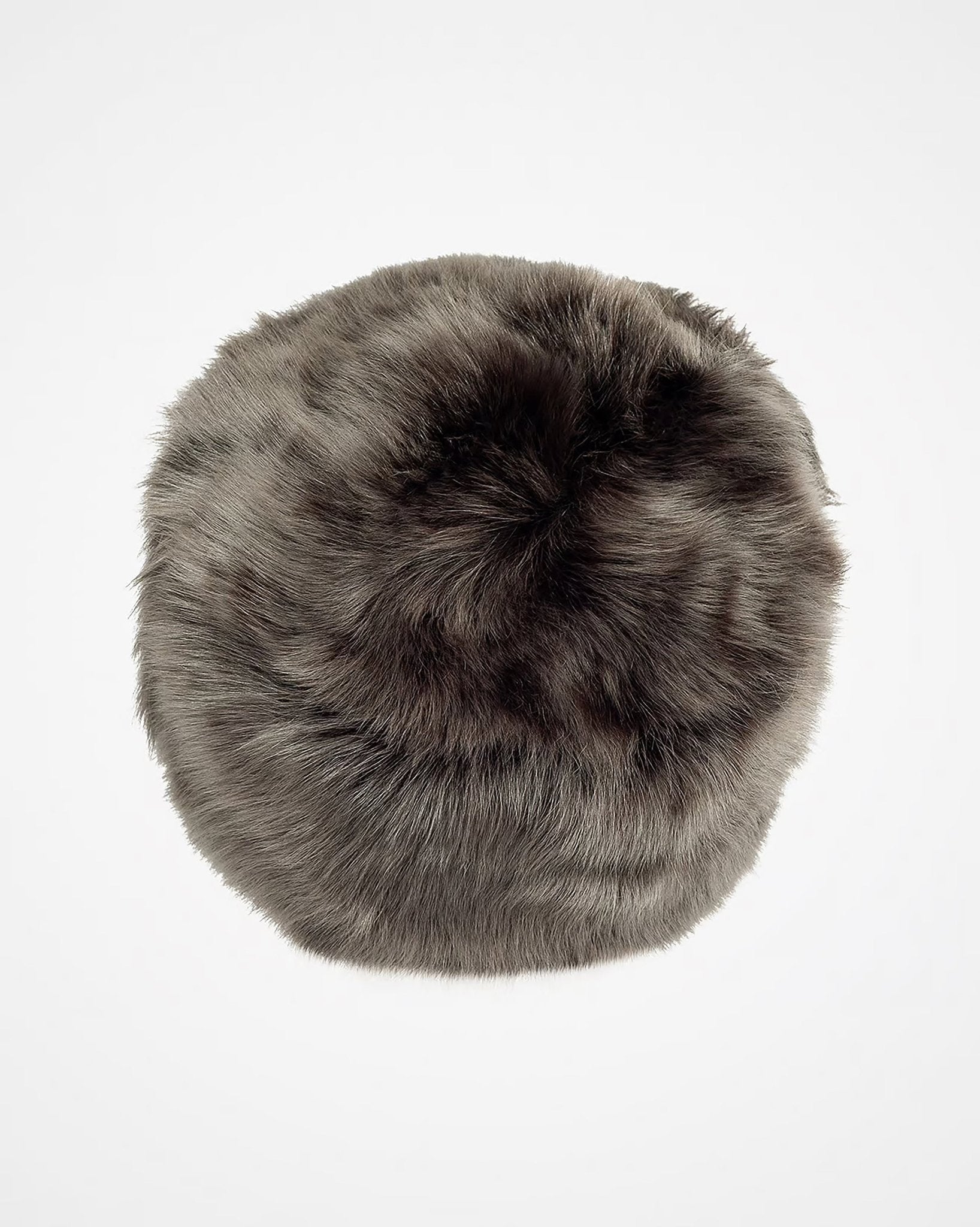 The Pillar Box Hat by Campbells of Beauly is a round, fluffy winter hat in natural Toscana sheepskin, viewed from above to showcase its insulating properties against a plain white background.