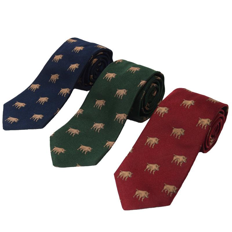 Three rolled-up Boar Silk Ties by Campbells of Beauly are shown side by side in navy blue, dark green, and burgundy, each handmade from silk and adorned with a charming small brown boar motif.