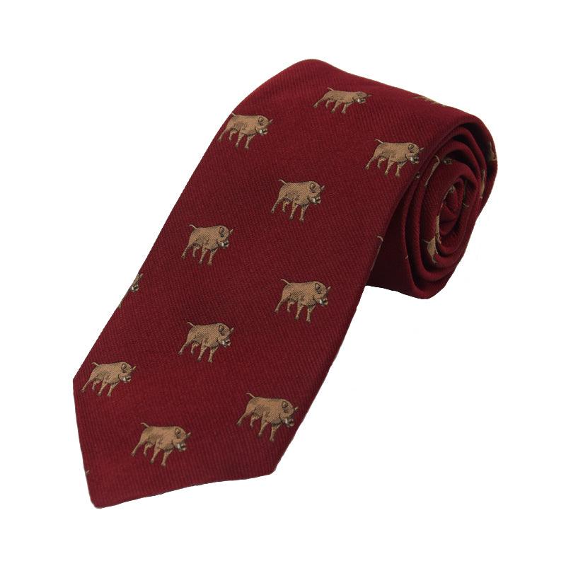 The Boar Silk Tie by Campbells of Beauly is a deep red, handmade silk tie featuring small embroidered brown boars in a repeating pattern. This classic countryside motif is shown rolled up against a white background.