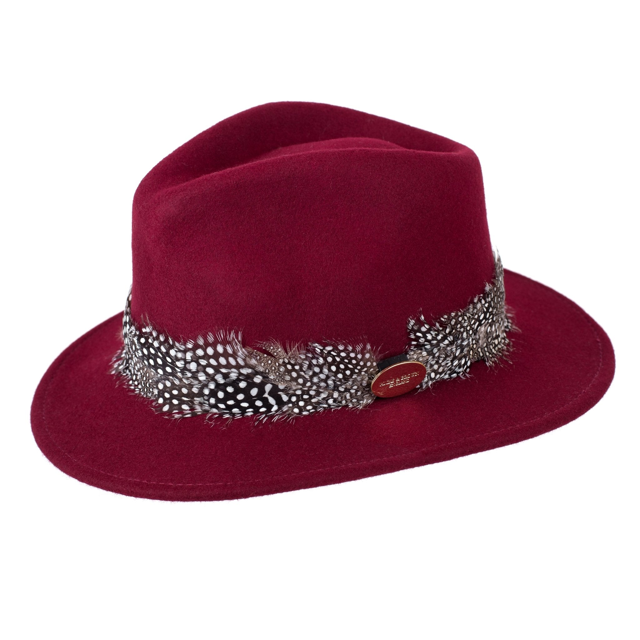 The Hicks & Brown Guinea Feather Maroon Fedora is a stylish, water-resistant wool felt hat featuring a maroon color, black-and-white spotted feather band, and a small oval metal tag, adding elegance to any outfit.