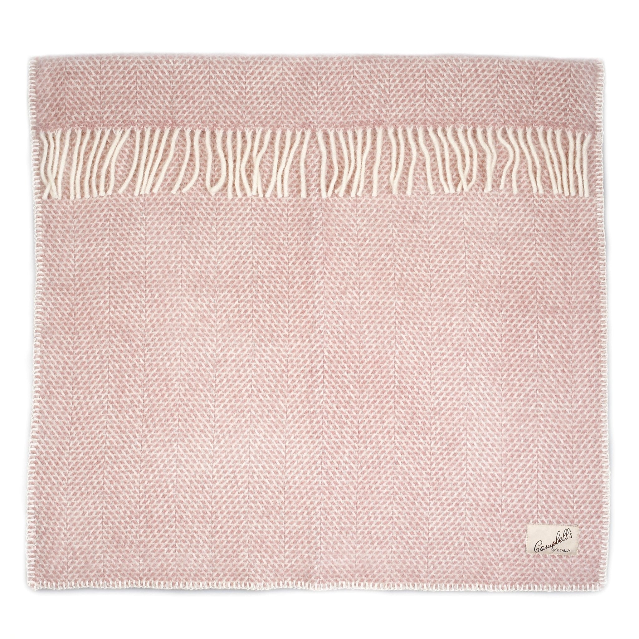 The Campbells of Beauly Baby Blanket in pink features a delicate pattern, white tassels on one edge, and a small corner label, providing soft comfort for your baby all year round.