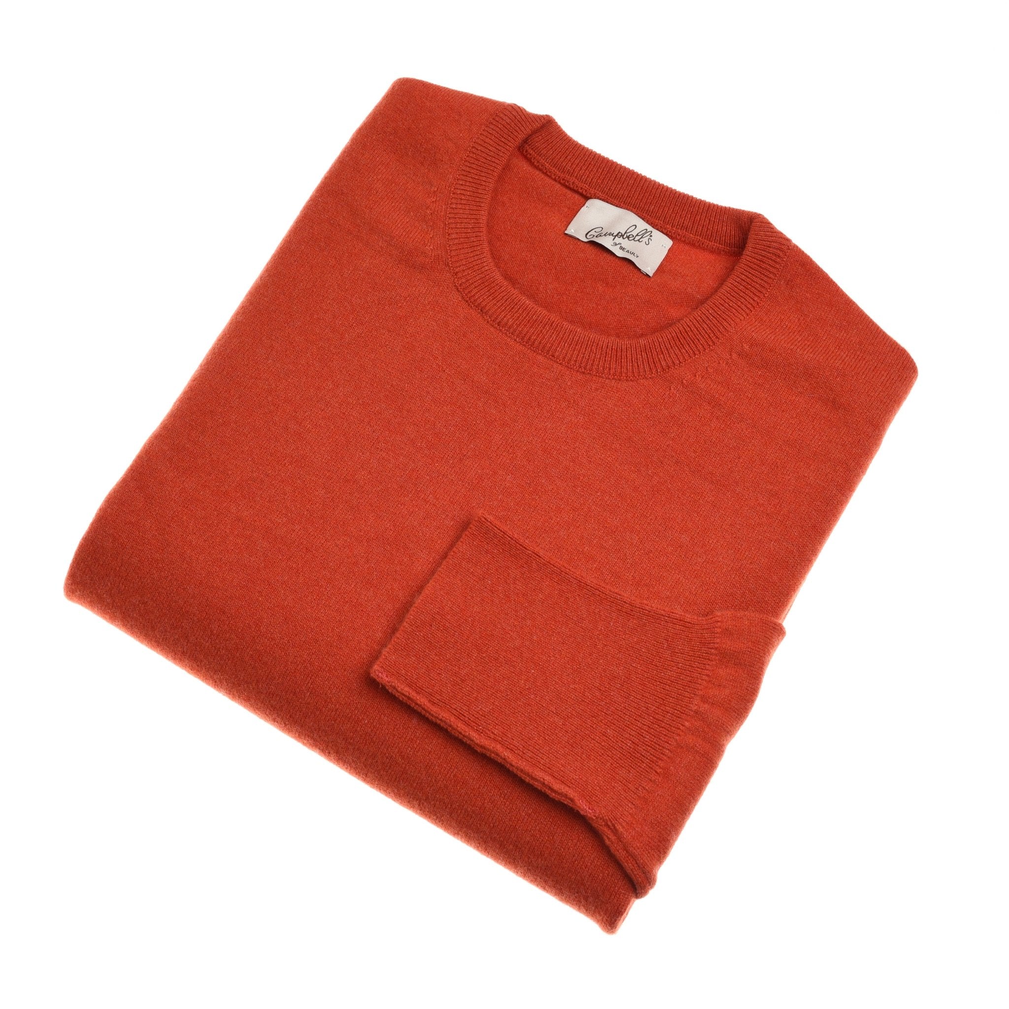 A neatly folded, long-sleeve burnt orange Cashmere Crew Neck Jumper by Campbells of Beauly with a visible collar tag and luxurious handle, displayed on a white background.