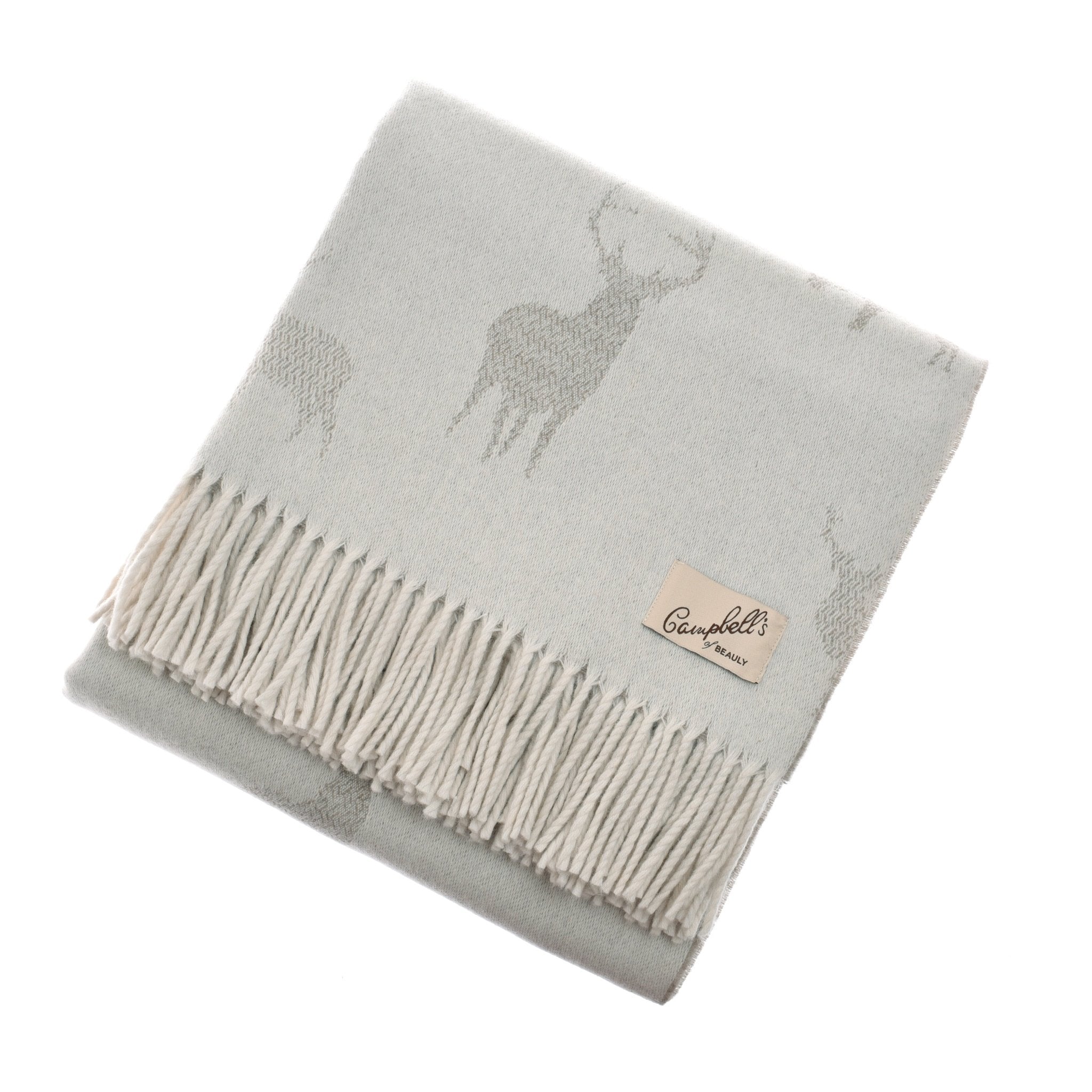The Stag Lambswool Blanket by Campbells of Beauly is a folded light grey lambswool blanket featuring a cosy stag pattern, delicate fringe, and a sewn-on beige label with the brand name.