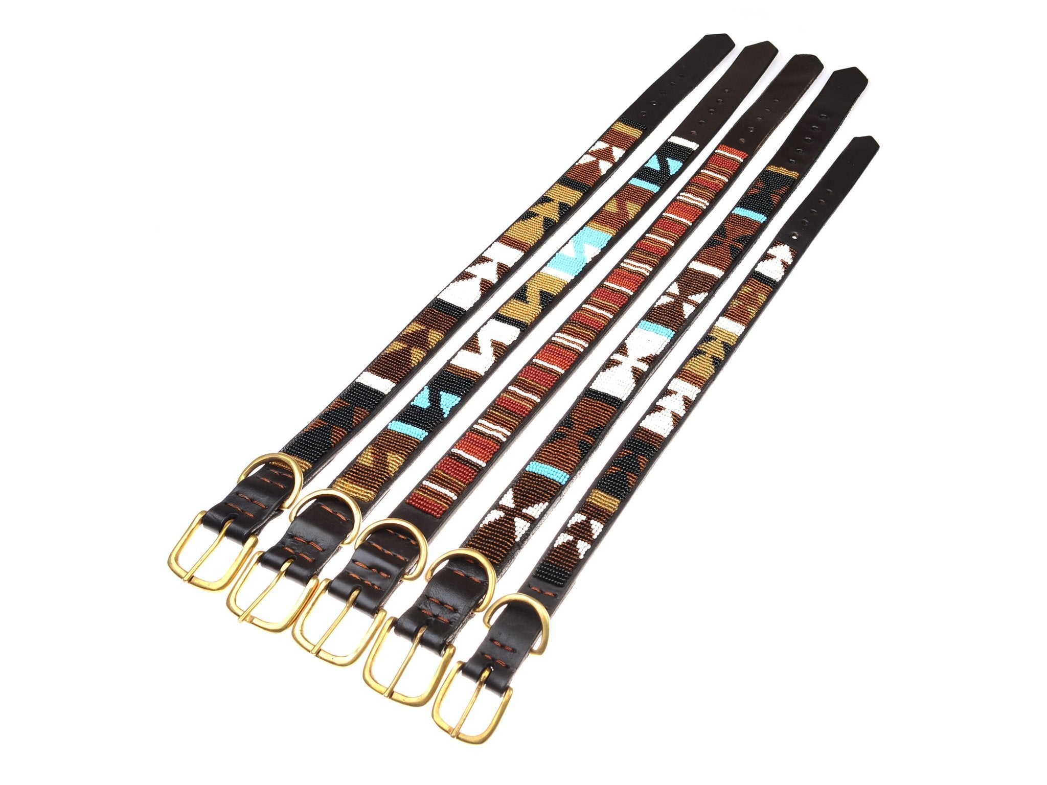 Five Campbell’s of Beauly Dog Collars with brass buckles, each featuring a beaded design inspired by Masai women in turquoise, brown, red, and white patterns, are laid side by side on a white background.