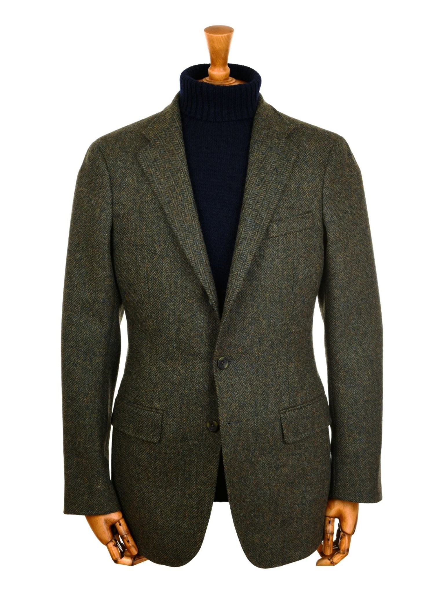 A Campbell's of Beauly Green Herringbone House Jacket with notched lapels is styled over a black turtleneck sweater and shown on a mannequin with wooden hands, set against a white background.