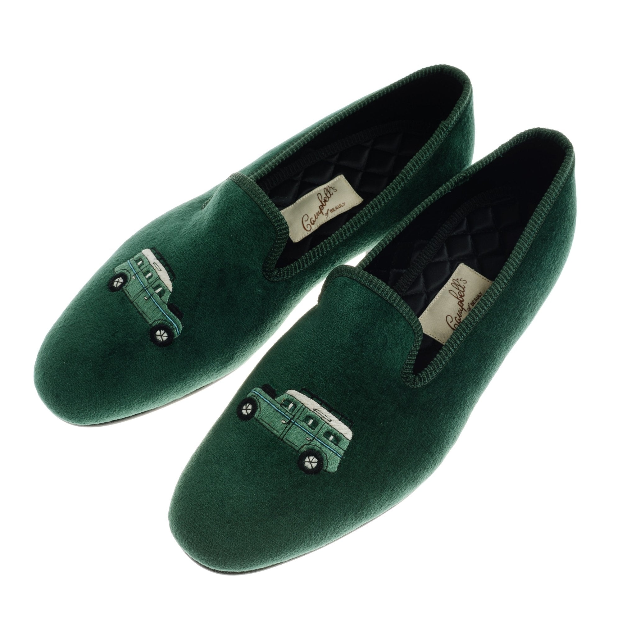 Campbells of Beauly Land Rover Defender Velvet Slippers feature dark green velvet, green car embroidery on the front, a quilted satin lining, and a leather sole for a soft, elegant look.