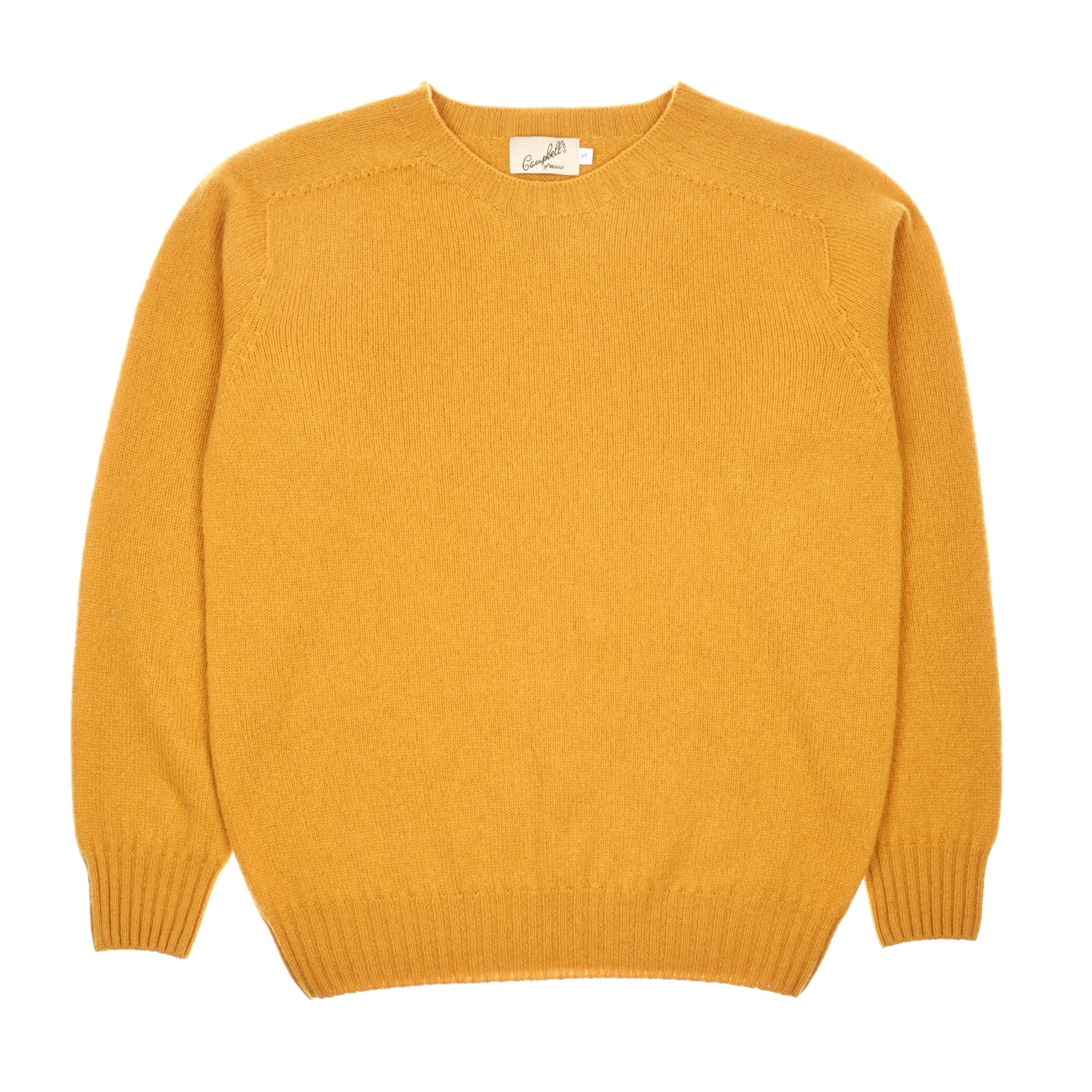 An ochre Geelong Lambswool Crew Neck Jumper by Campbells of Beauly is laid flat on a white background. The long-sleeve jumper has ribbed cuffs, hem, and collar with a visible neckline tag. Made in Scotland.