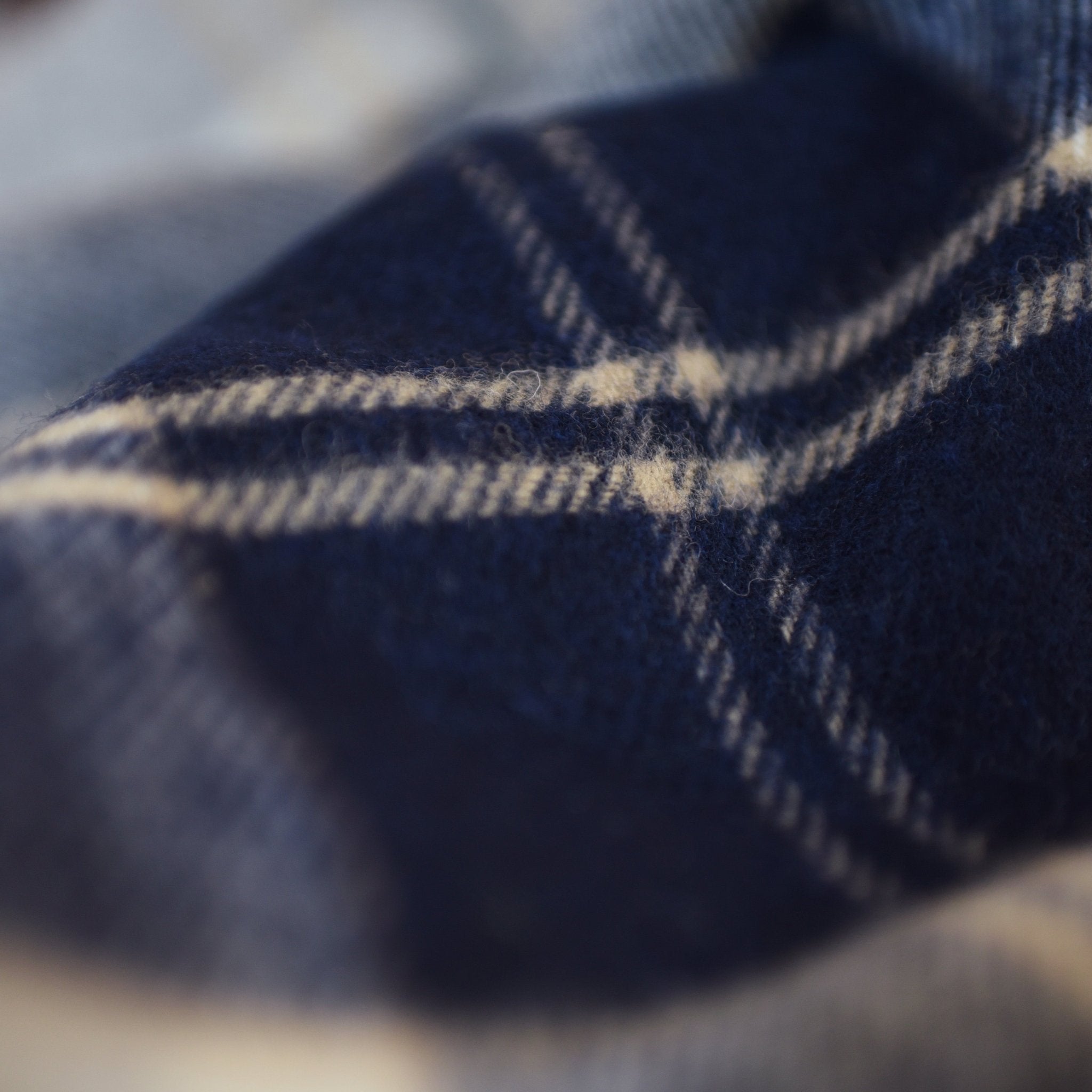 Close-up of the Silver Bannockbane Lambswool Throw by Campbells of Beauly in navy and white plaid, highlighting its soft, fuzzy texture and classic Yorkshire-inspired crisscross pattern.