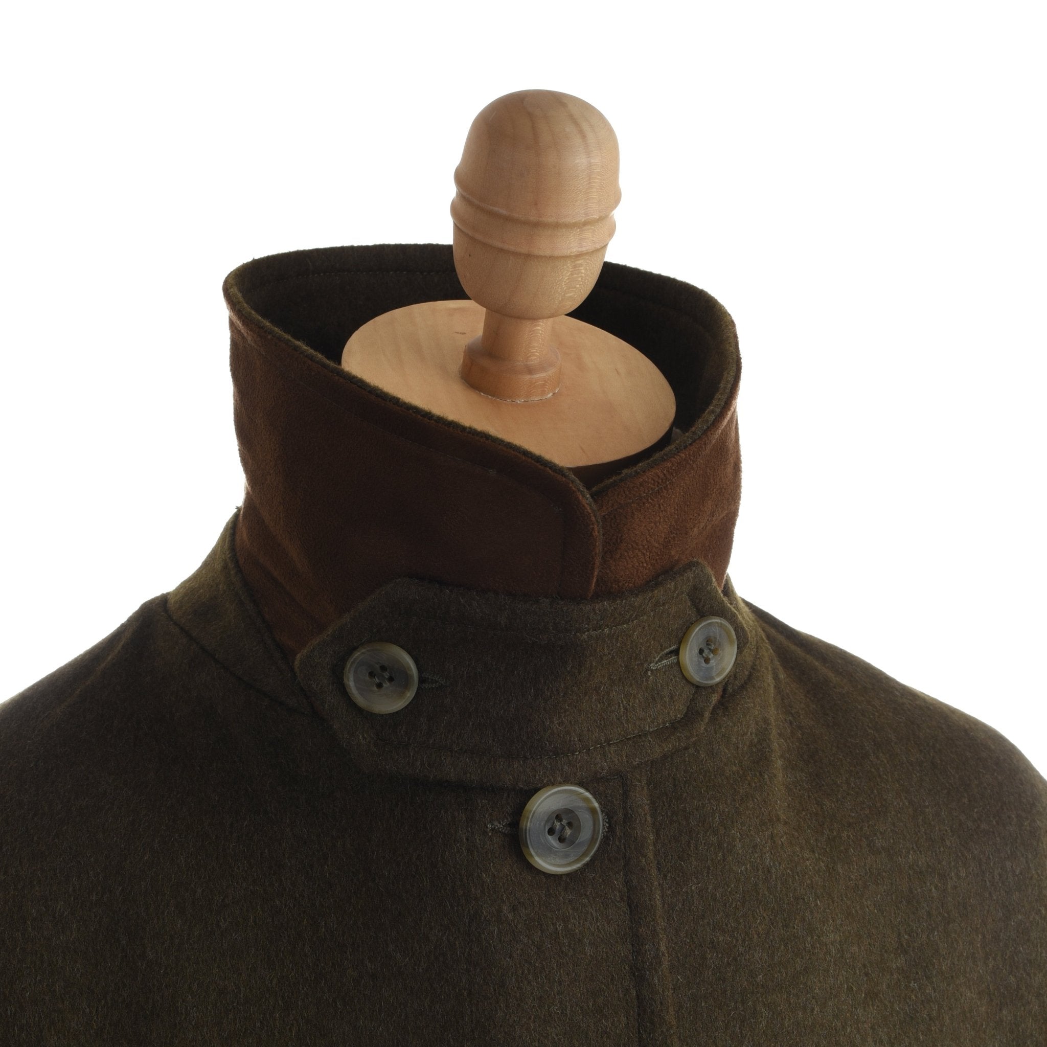 A wooden mannequin displays the Campbells of Beauly Loden Green Cape, featuring a high buttoned collar, dark brown lining, and large buttons—a heritage-inspired piece shown against a plain white background.