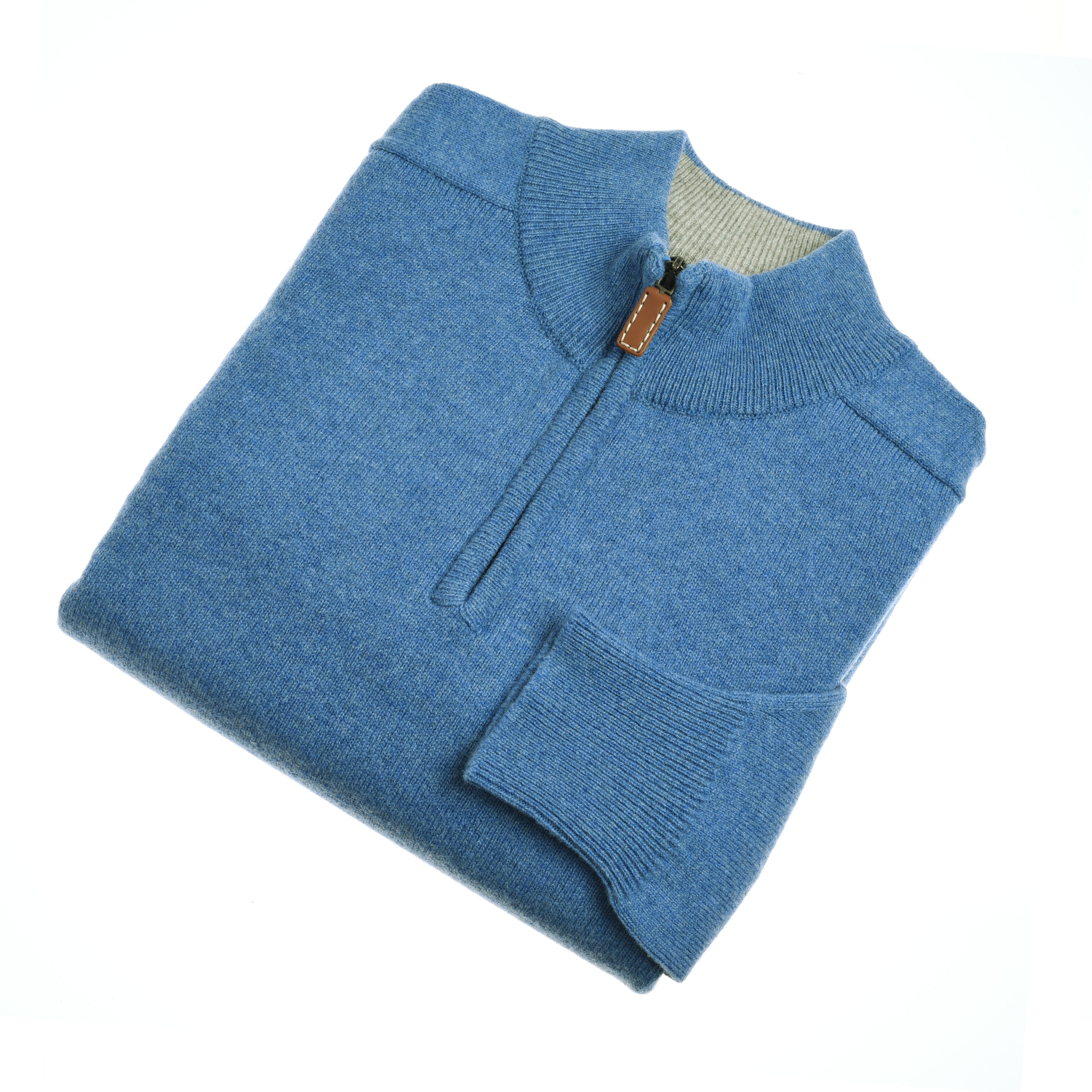 The Campbells of Beauly Lambswool Quarter Zip Jumper is neatly folded in blue, featuring a half-zip front with a brown leather pull, ribbed collar, cuffs, and hem—crafted in the Scottish Borders and displayed on a white background.