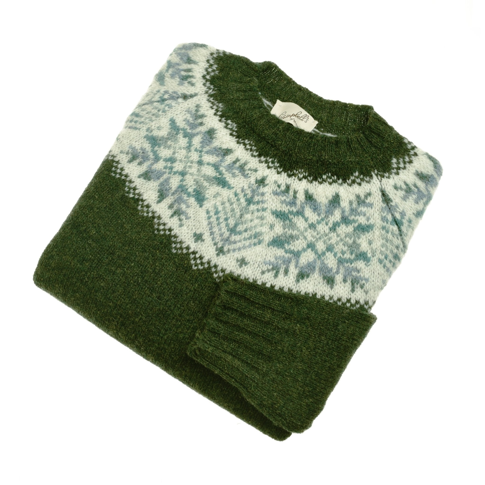 The Campbells of Beauly Shetland Wool Snowflake Crew Jumper in Pine features a white and light blue Fairisle snowflake design across the chest and shoulders, shown folded on a white background.