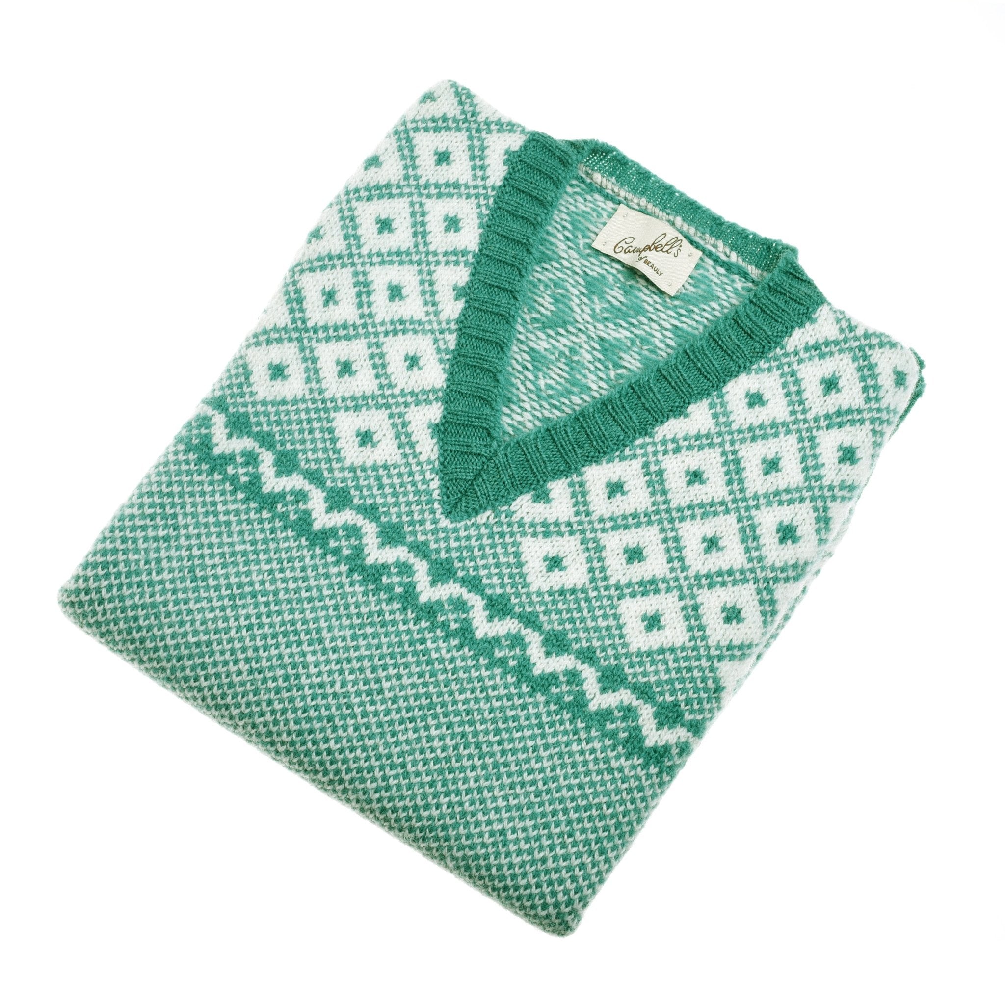 The Campbells of Beauly Nordic V Tank in verdigris, a green and white diamond-patterned knitted slipover crafted from soft Shetland wool, is neatly folded on a white background.