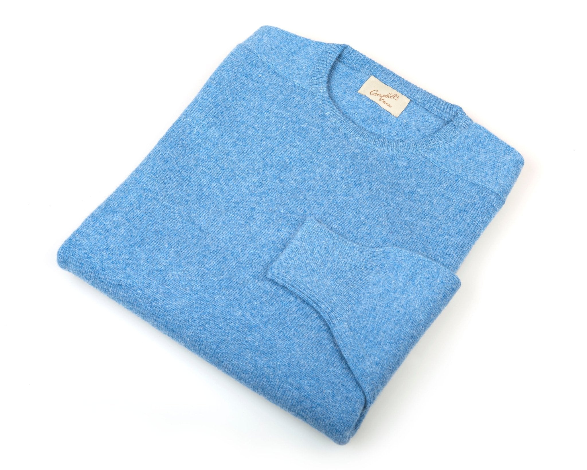 A neatly folded light blue Campbells of Beauly Lambswool Crew Neck Jumper with its label visible on the collar, set against a white background.