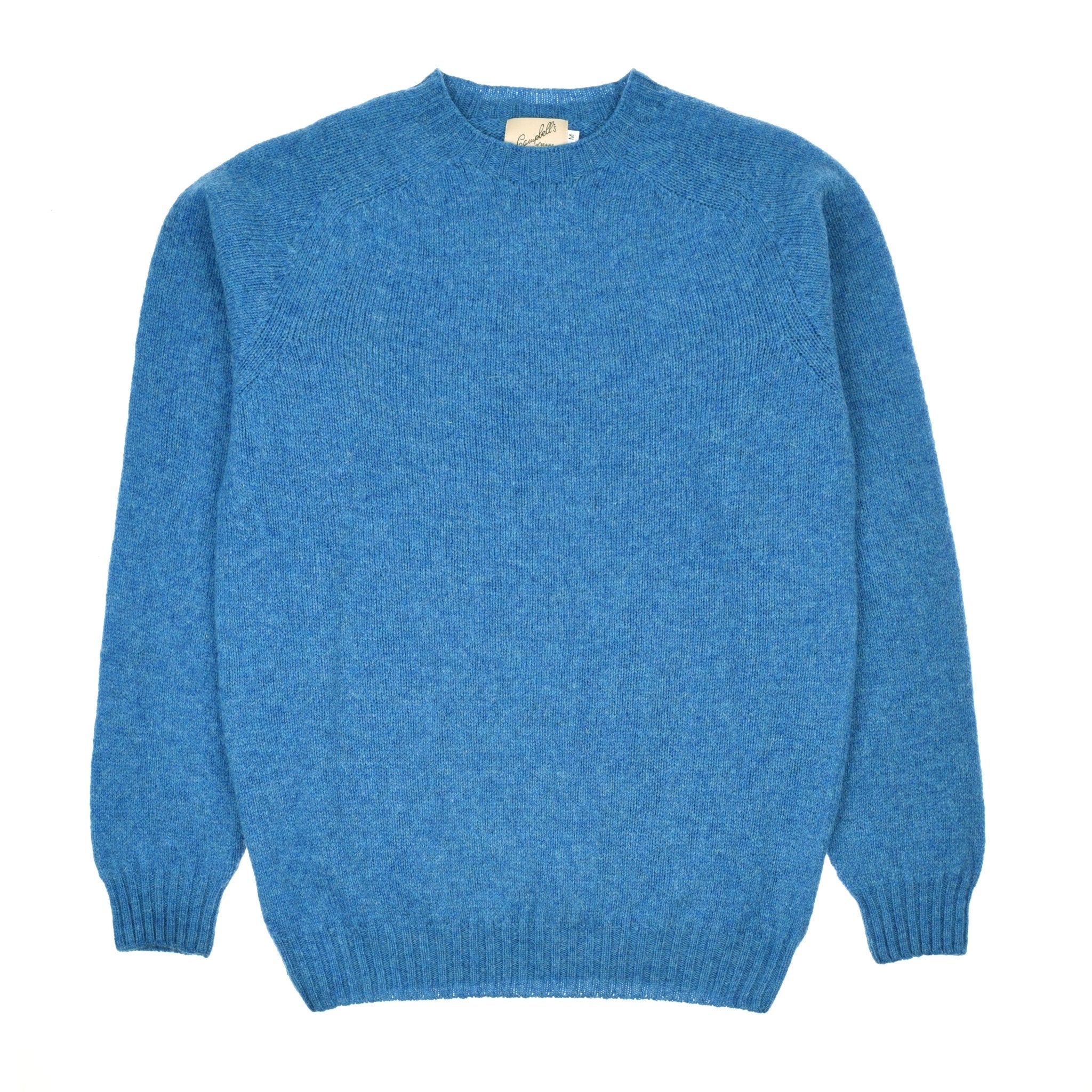 The Campbells of Beauly Shetland Jumper, a soft knitted lambswool blue crew-neck sweater with long sleeves, is laid flat on a white background.