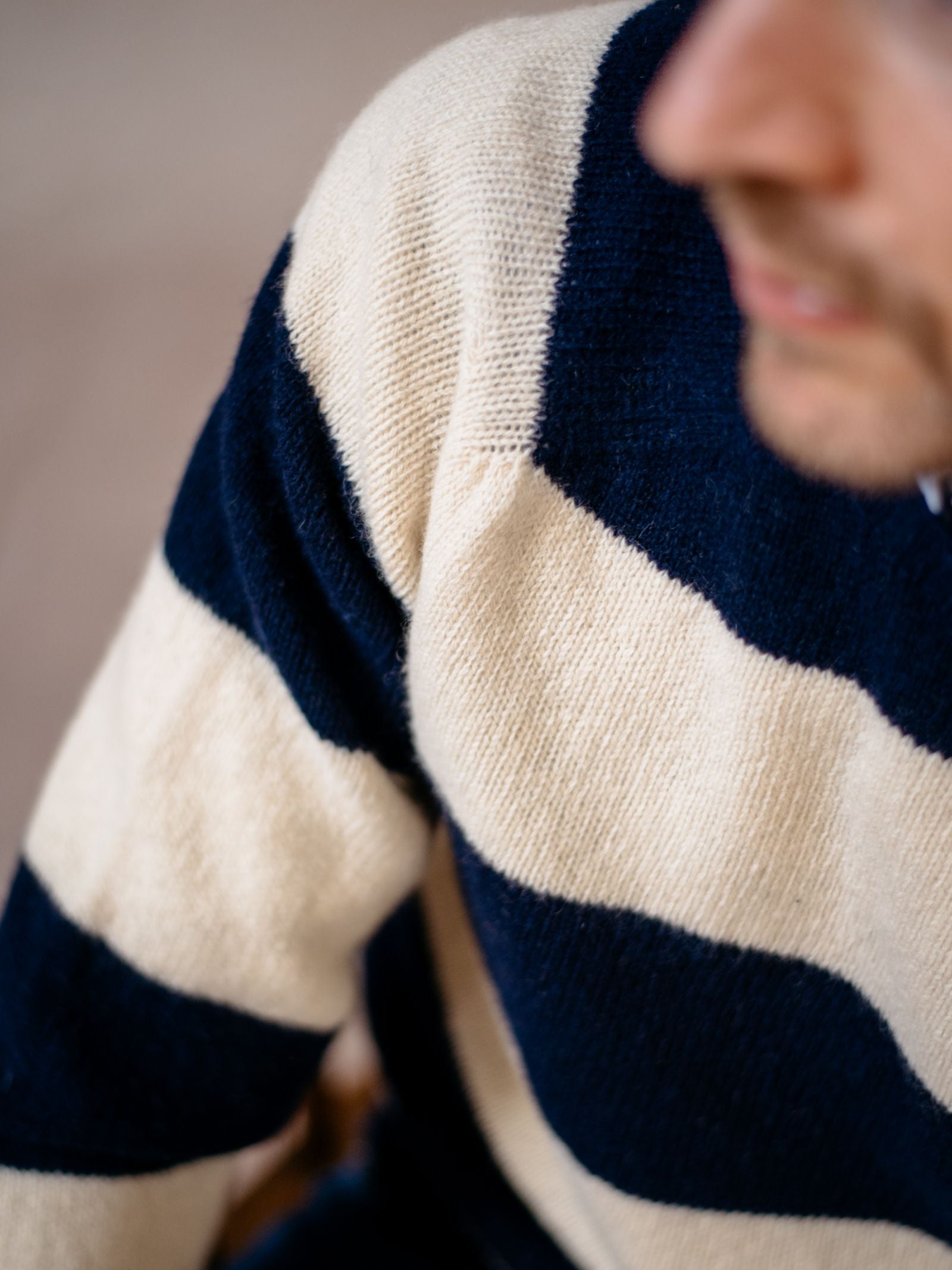 Close-up of a person wearing the Campbell’s of Beauly Shetland Stripe Crew Jumper, featuring classic wide horizontal navy blue and cream stripes; the face is blurred to emphasize the timeless stripe design.