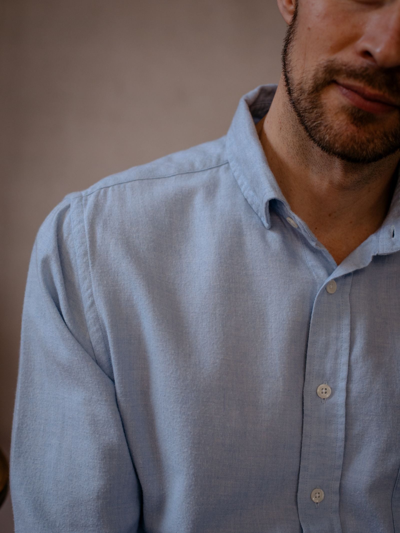 A man with short facial hair models the Campbells of Beauly Twill Shirt in a light blue, classic fit. The cropped image shows his torso and part of his face against a neutral blurred background.