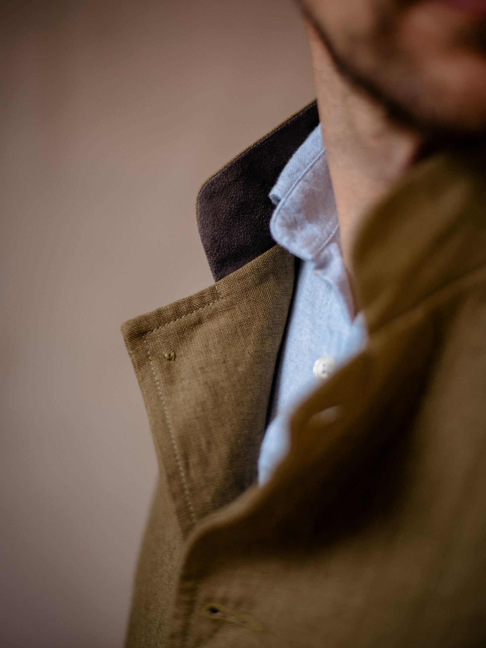 Close-up of a mans lower face and neck, wearing a light blue shirt under a Linen Nehru Gilet by Campbells of Beauly—the ideal summer layer. The softly blurred background enhances the gilet’s elegant details.