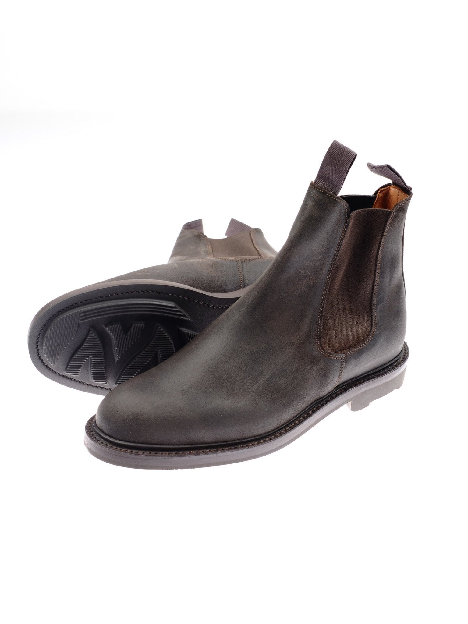 The Campbell's of Beauly Lowlander Boots are handmade in England from dark brown leather, with elastic side panels, pull tabs, and textured rubber soles. One boot stands upright; the other lies on its side to show the sole.