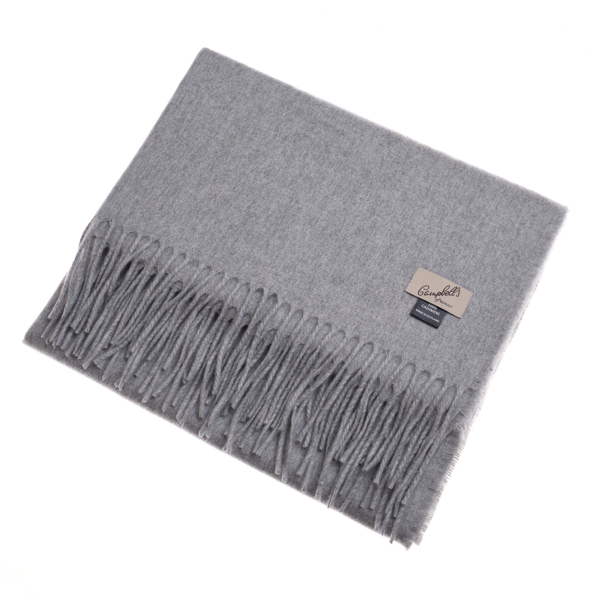 The Campbell's of Beauly Unisex Cashmere Scarf is a light gray accessory with fringed edges and two corner labels—a rectangular beige one and a dark blue one—offering timeless luxury in a neatly folded design.