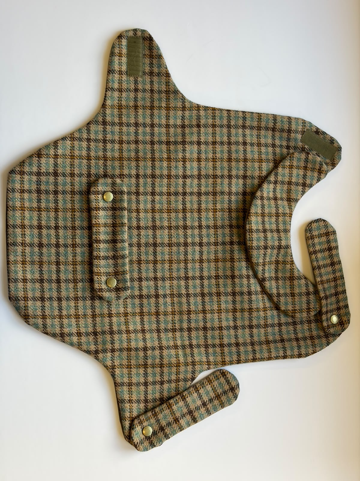 A House Tweed Dog Coat M by Campbell's of Beauly, featuring a flat plaid-patterned fabric with three snap fasteners and uniquely shaped flaps, displayed on a white background.