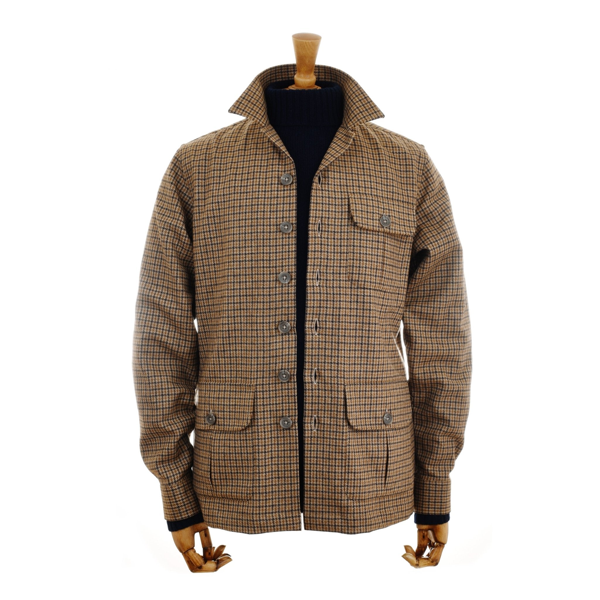 The Campbells of Beauly Casual Shacket in Gun Club features a button-up front, three flap pockets, a high collar, and black ribbed cuffs—combining modern ease with traditional tailoring, displayed on a wooden mannequin torso.
