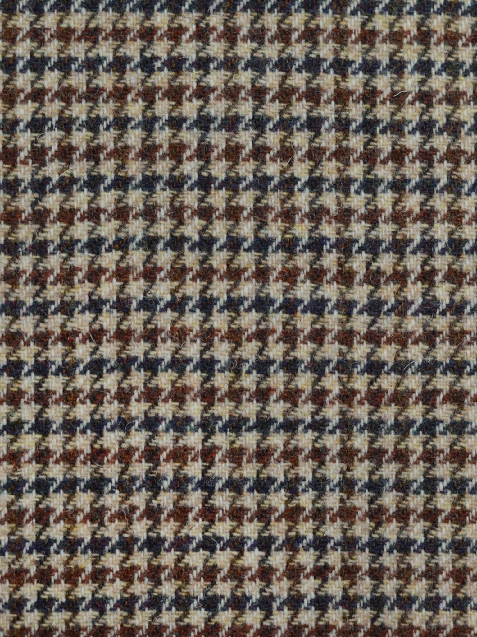 Close-up of House Tweed 93896 by Campbell's of Beauly, featuring a classic houndstooth pattern in brown, beige, and black—showcasing tightly woven, Scottish textile heritage.