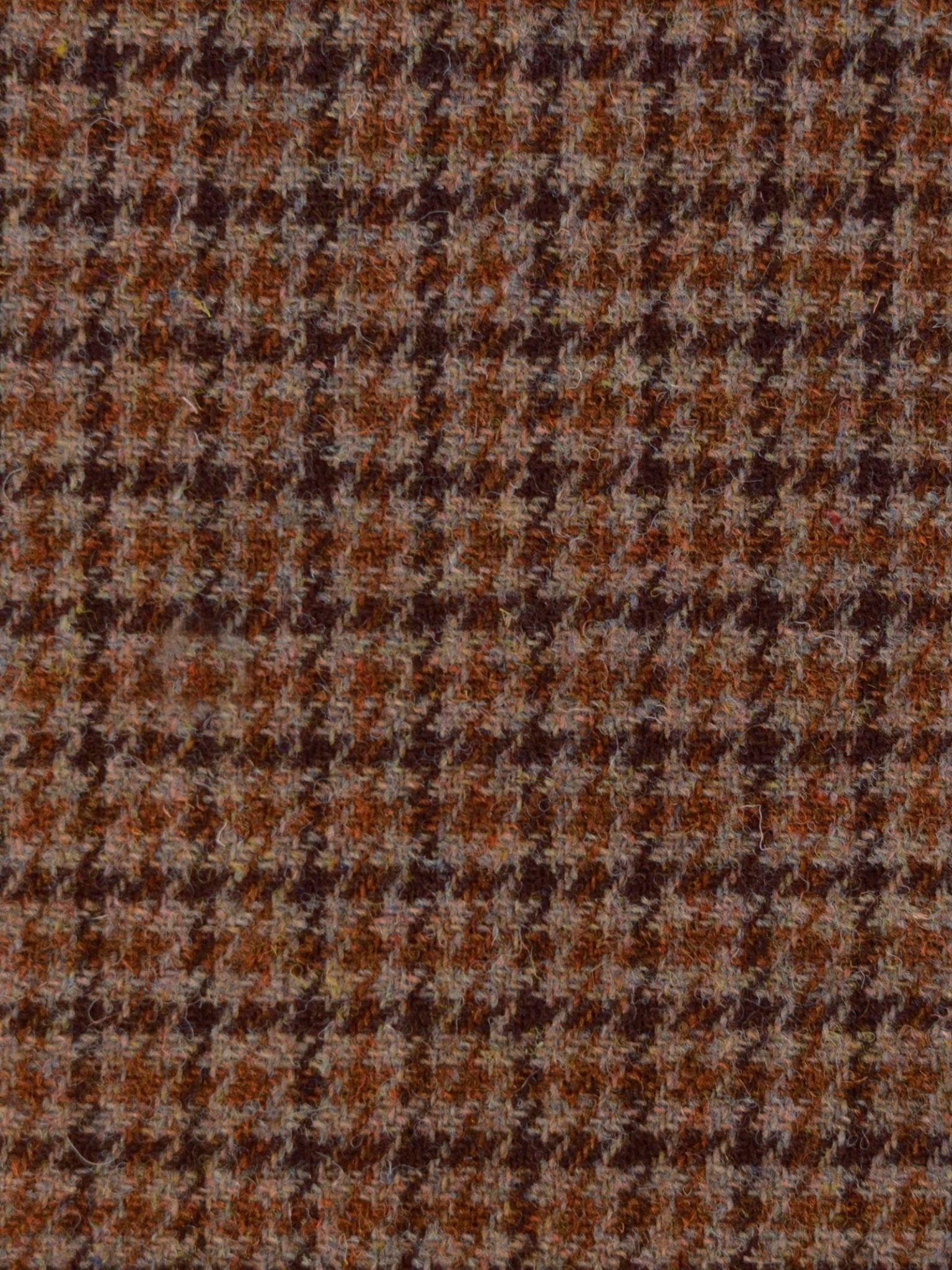 Close-up of House Tweed 93910 by Campbell's of Beauly, showcasing a brown and tan houndstooth pattern with classic jagged checks and a textured, woolen surface inspired by traditional Scottish weaving.