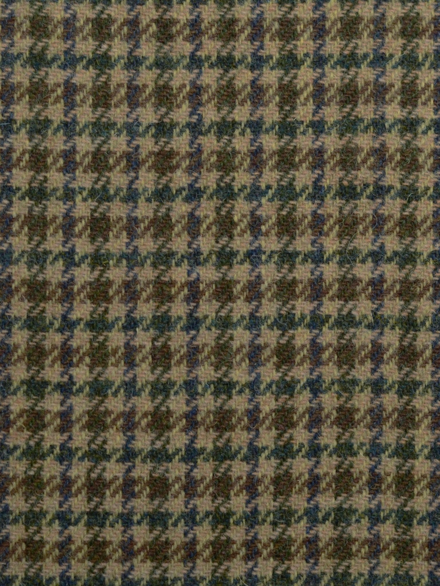 A close-up of House Tweed 93912 by Campbell's of Beauly: featherweight tweed with a houndstooth pattern in muted brown, green, and blue hues, highlighting the geometric design typical of Scottish weaving.
