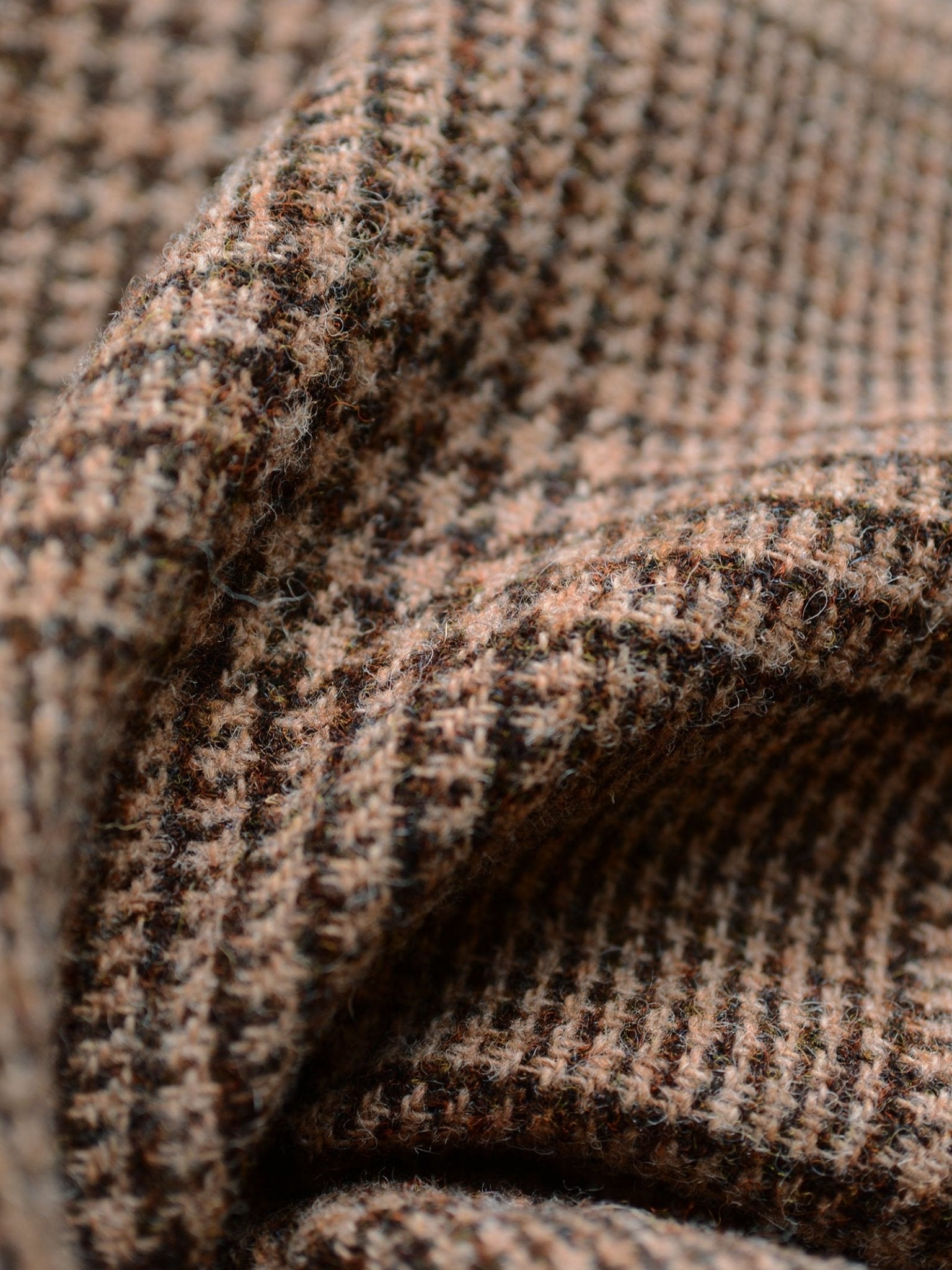Close-up of Harris Tweed 79336 by Campbell's of Beauly, highlighting brown and beige houndstooth pattern, textured weave, and soft folds—reflecting classic tailoring and traditional Scottish craftsmanship.