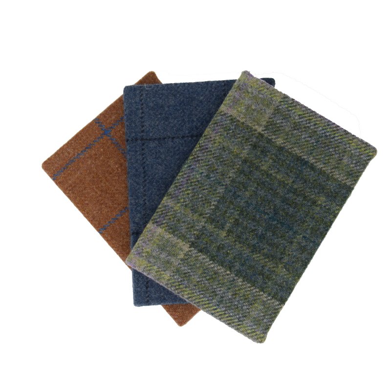 Three Campbells of Beauly Tweed Notebooks, in brown, blue, and green plaid fabric covers, are arranged in a slightly overlapping fan shape on a white background.