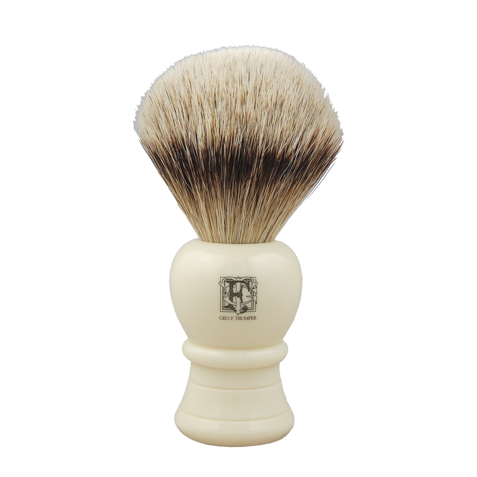 The Geo. F. Trumper Shaving Brush features a white handle with a printed emblem and dense, soft badger hair bristles for building a rich lather during your traditional wet shave.