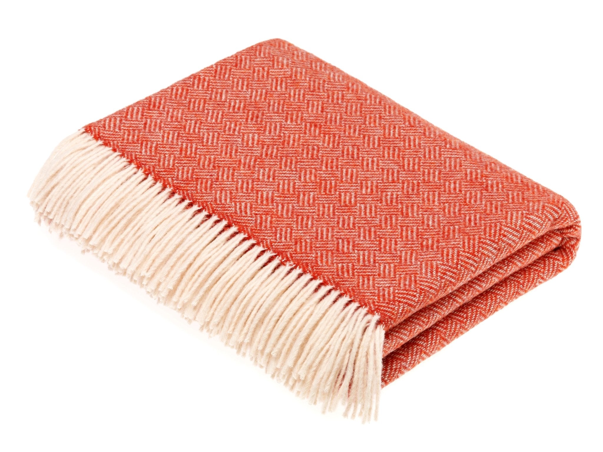 The Campbells of Beauly Parquet Lambswool Blanket in coral features a subtle parquet weave and a cream fringe on one end, neatly folded and displayed on a white background.