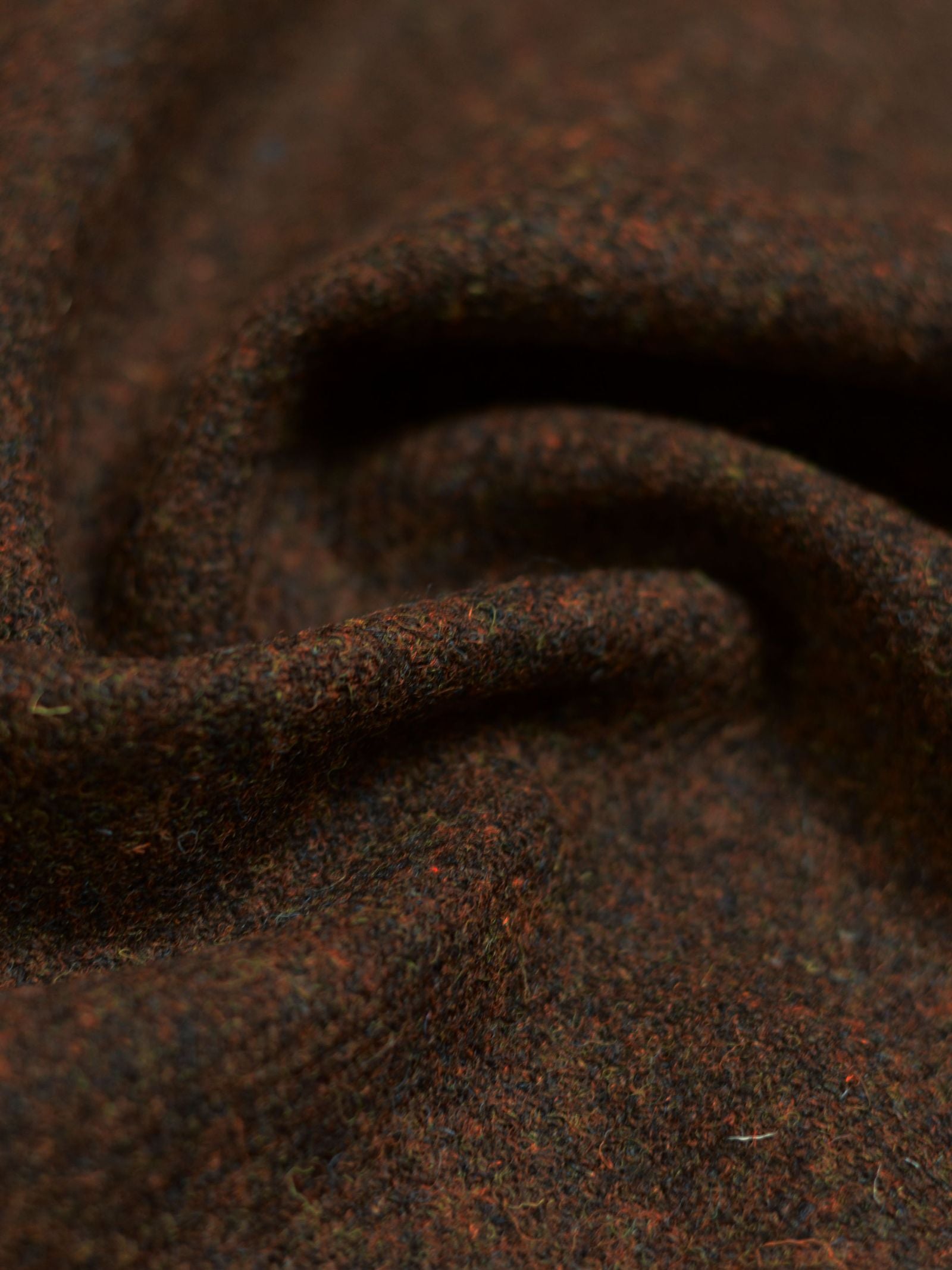 Close-up of House Tweed 93893 by Campbell's of Beauly, showcasing textured brown wool with visible fibers and soft folds, evoking classic Scottish weaving through gentle waves and subtle shadows.