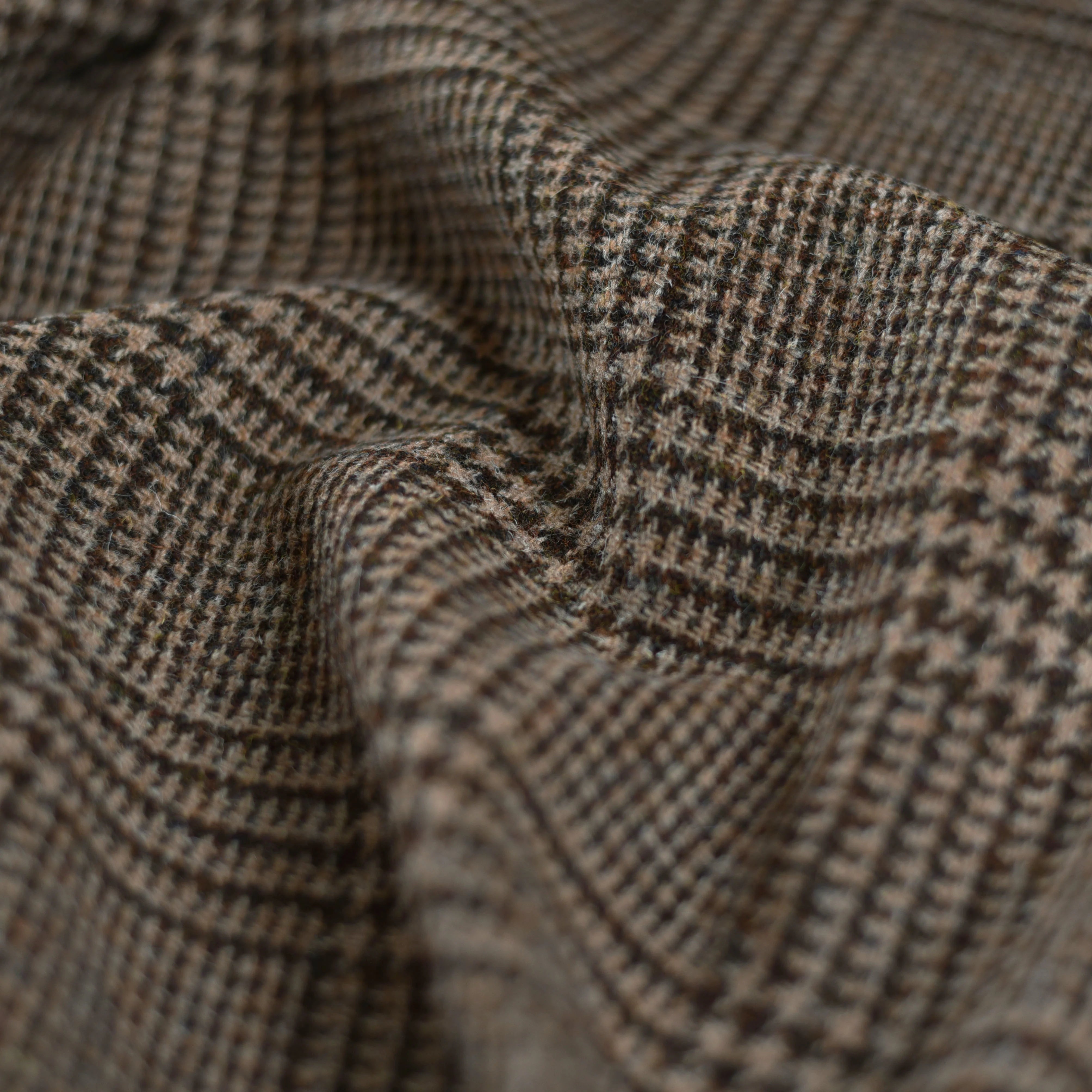 A close-up of House Tweed 79336 by Campbells of Beauly shows its brown and beige houndstooth pattern, woven texture, soft folds, and detailed check design that reflects heritage craftsmanship.