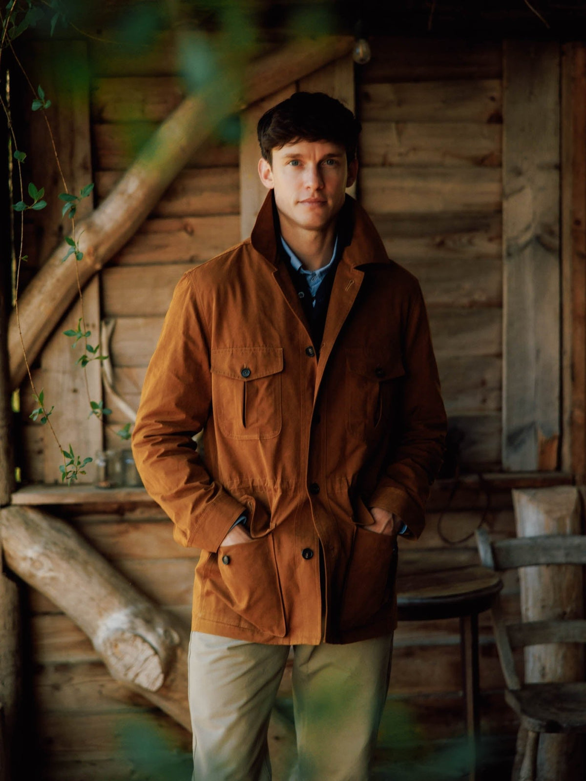 A man wearing a Campbell’s of Beauly Aigas Field Jacket in brown peach skin fabric, featuring four large front pockets and a high collar.