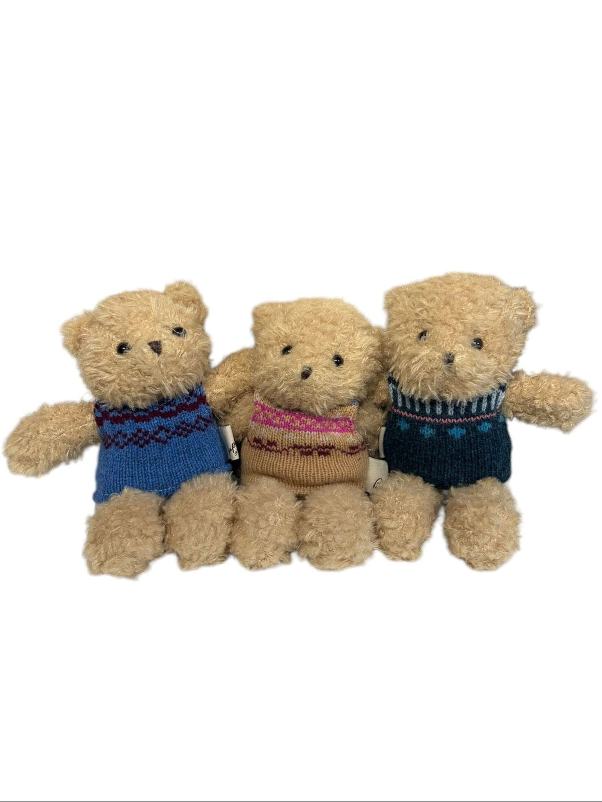 Three plush teddy bears sit side by side, each dressed in a different knitted sweater—blue, brown, and dark blue. Among them is Bobby the Bear from Campbell’s of Beauly, proudly displaying charming knitwear as they are arranged against a white background.