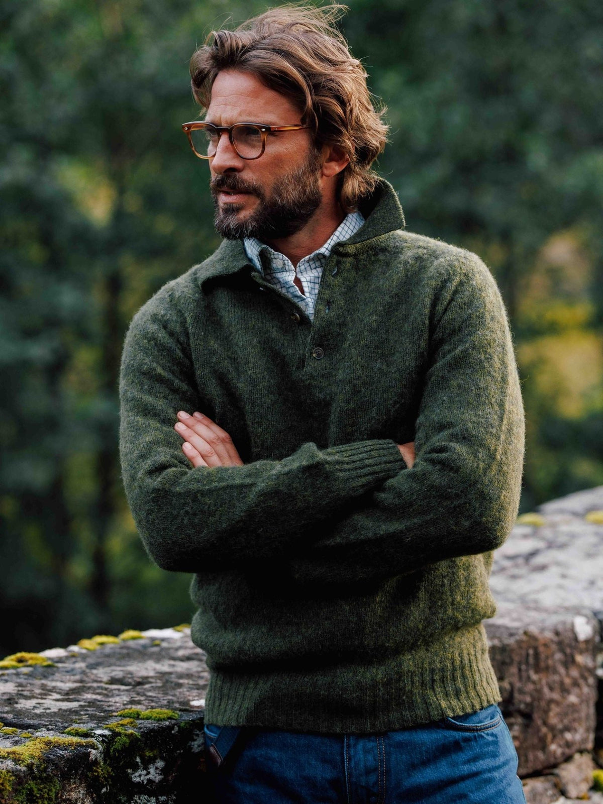 A man wearing a green Brushed Shetland Rugby Jumper by Campbell’s of Beauly over a plaid collared shirt.