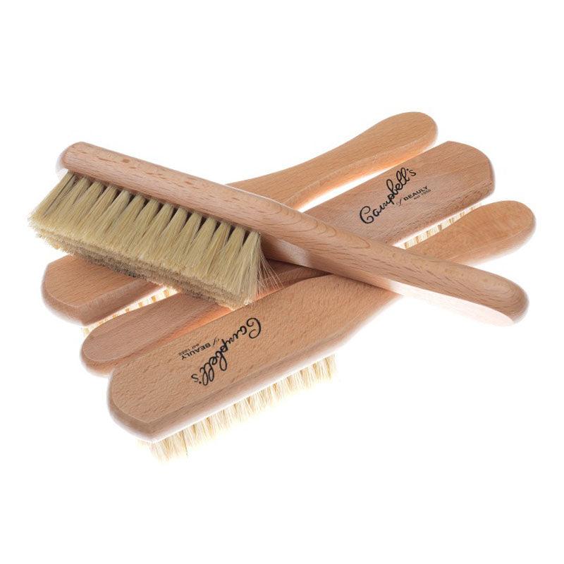 Five Campbell’s Clothes Brushes by Campbell’s of Beauly with light bristles are stacked slightly askew. Each wooden handle is engraved with the brand name, making them ideal for garments and pet owners.