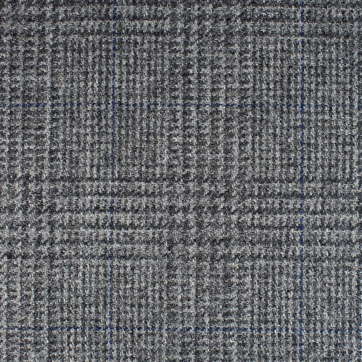 Field Tweed 111 is a grey 100% wool tweed fabric featuring a subtle glen check pattern with thin navy blue overcheck lines, perfect for country clothing.