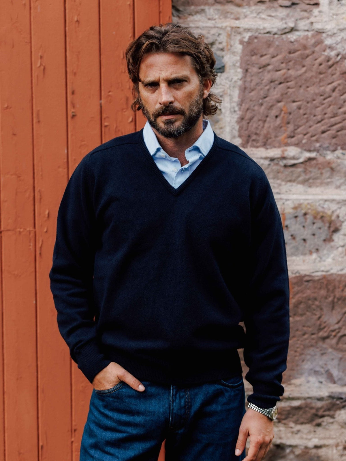 A man wearing a Campbell’s of Beauly Lambswool V-Neck Jumper over a light blue collared shirt.