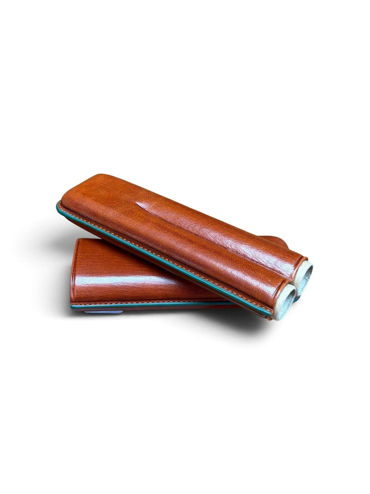 Two brown “Rey Pavón” Leather Cigar Cases, reminiscent of expertly crafted leather pen cases, are stacked one atop the other. Each case features visible stitching and rounded edges, beautifully showcased against a white background.