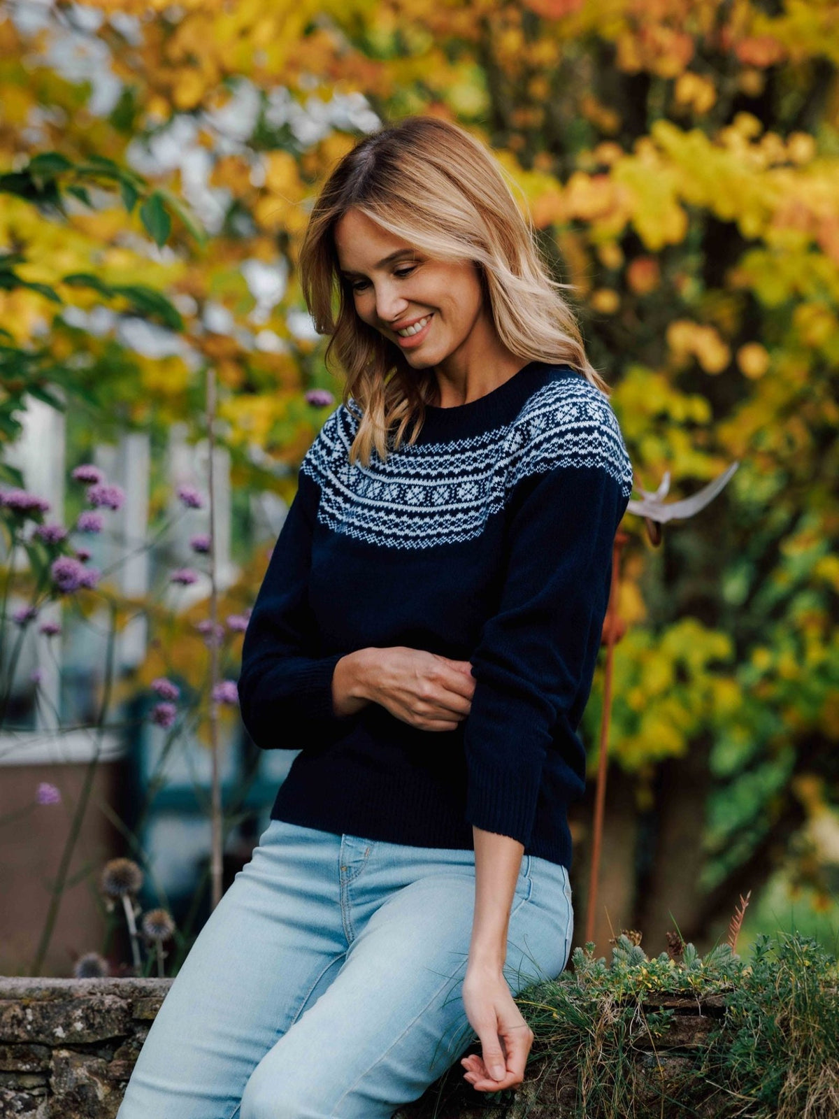 A woman wearing a Campbell’s of Beauly Two-Colour Fairisle Yoke Jumper in dark blue with a white patterned yoke.